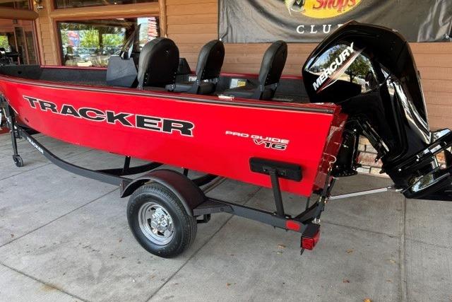 2026 Tracker Pro Guide V-16 SC boat with Mercury engine, red exterior, parked on trailer.