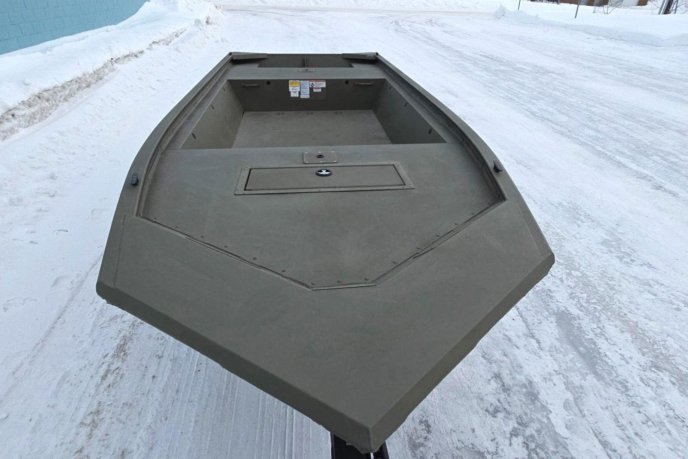 2025 Tracker Grizzly 1648 Jon boat on snowy ground, showcasing its sturdy design.
