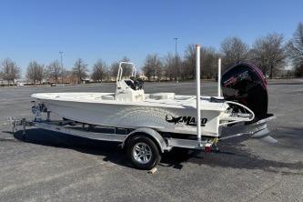 2026 Mako 18 Pro Skiff boat on trailer in parking lot, clear sky background.