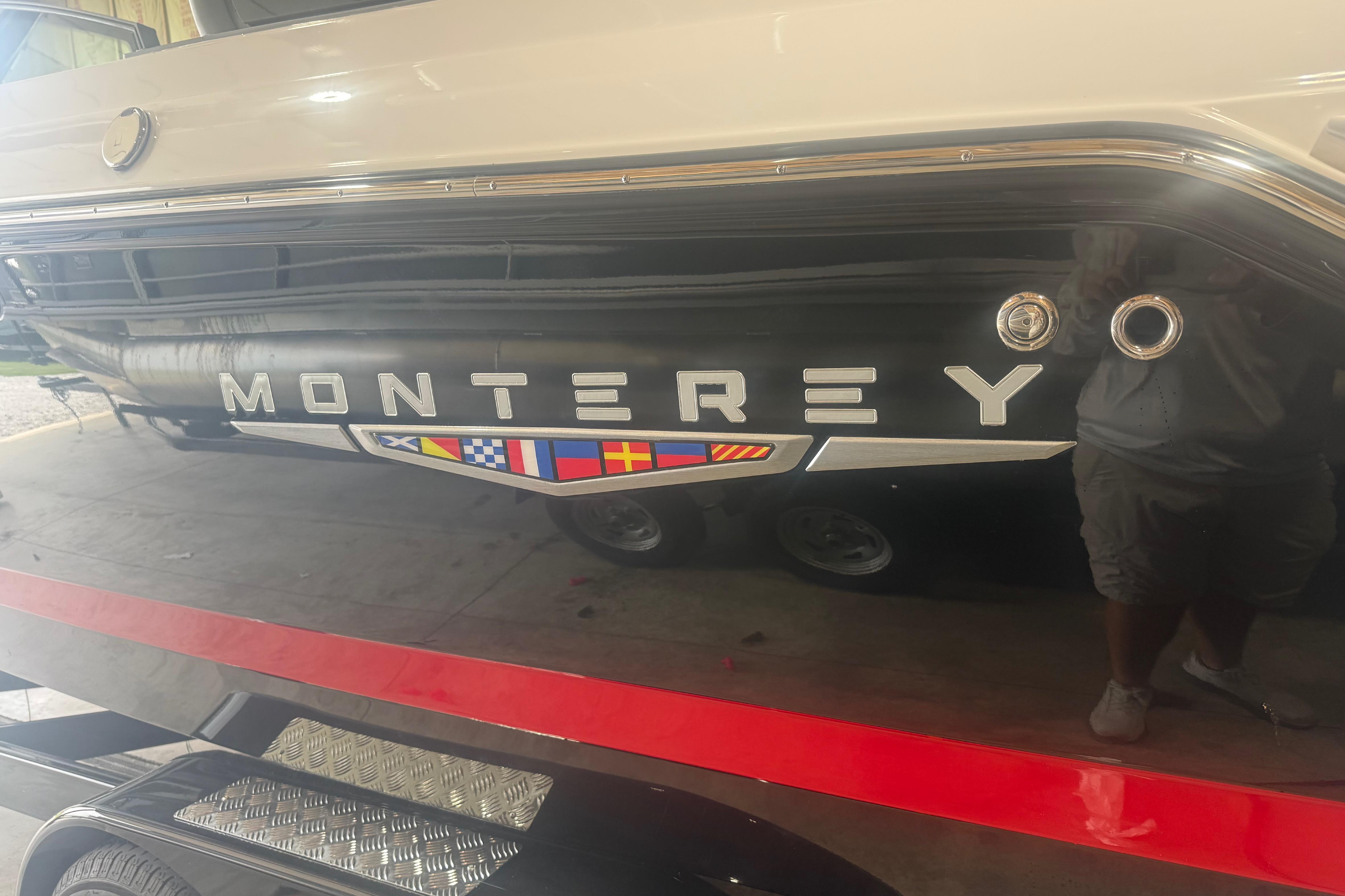 2027 Monterey Elite 27 SD boat with nautical flags, parked indoors.