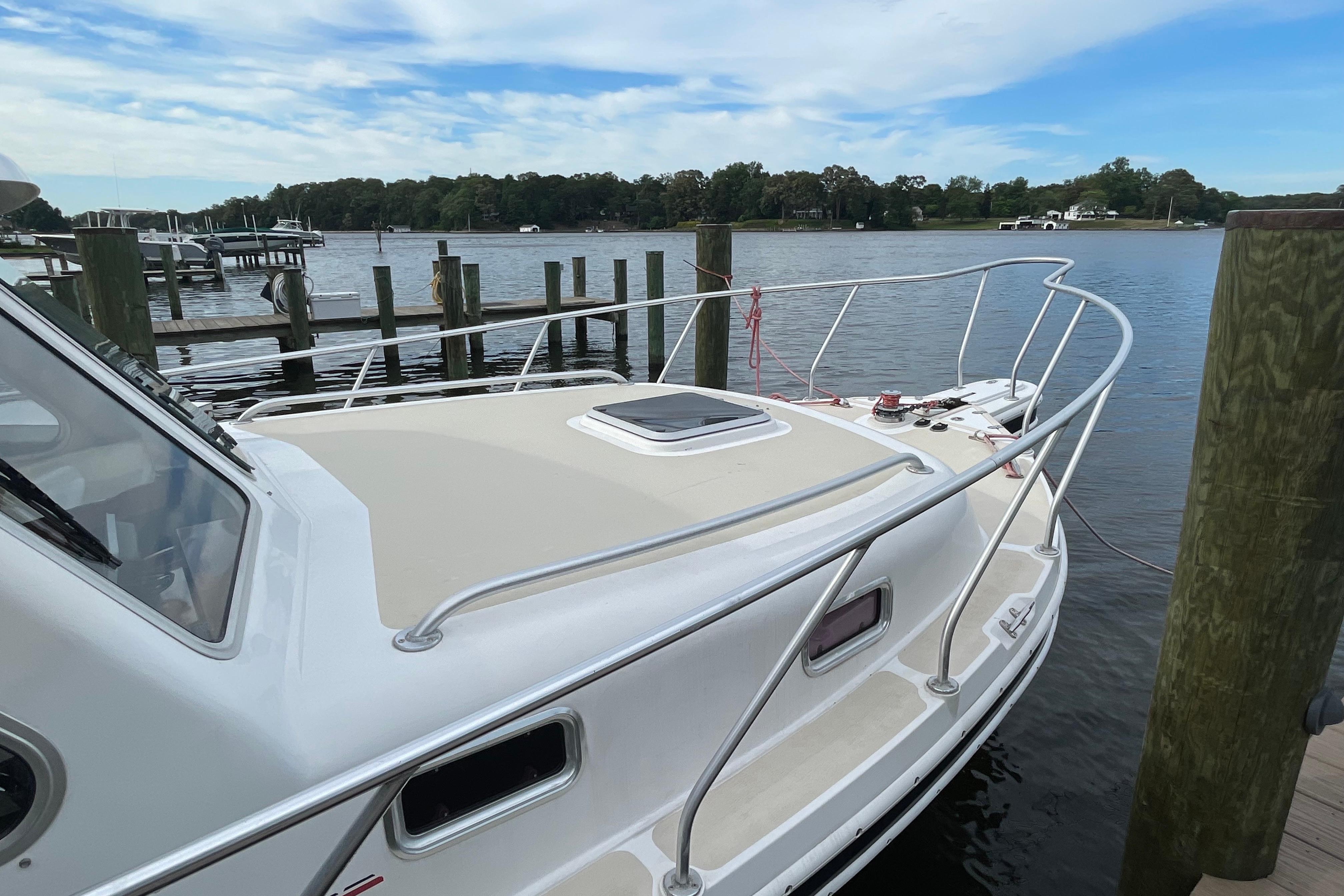 2005 Fox Island Thirty Sedan Cruiser docked by a serene waterfront.