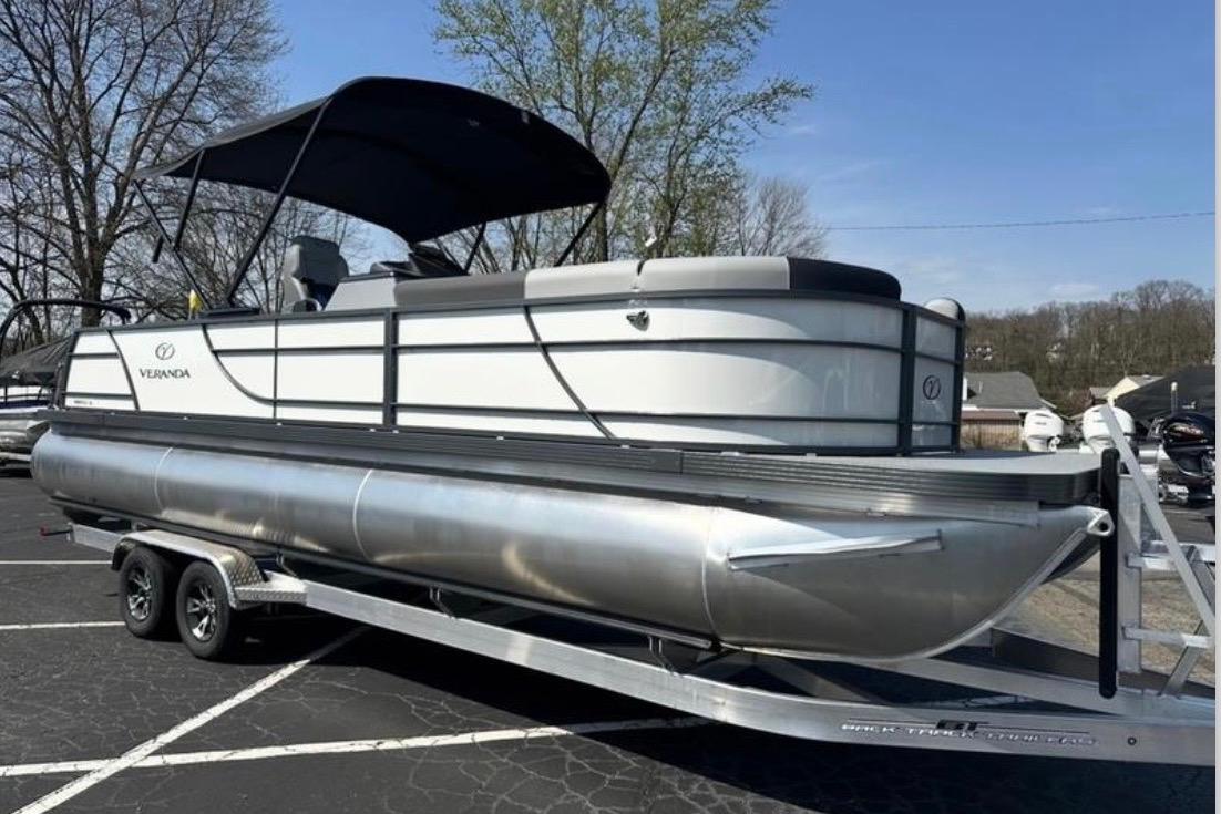 2025 Veranda Relax VR25VLC pontoon boat on trailer, parked outdoors.