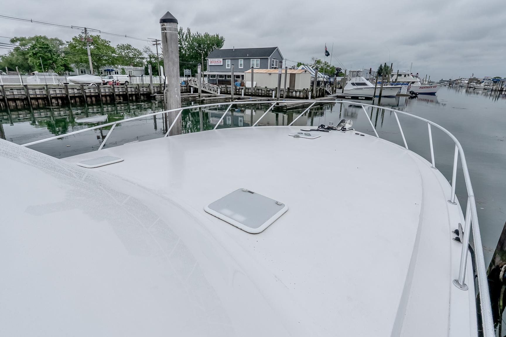 Bow view of a 2000 Viking 50' Convertible yacht docked in a marina.