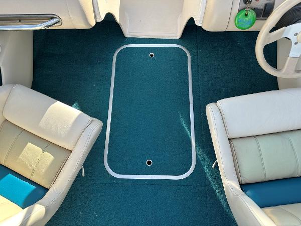 Interior of a 1995 Larson 174 SEI boat with teal carpet and beige seats.