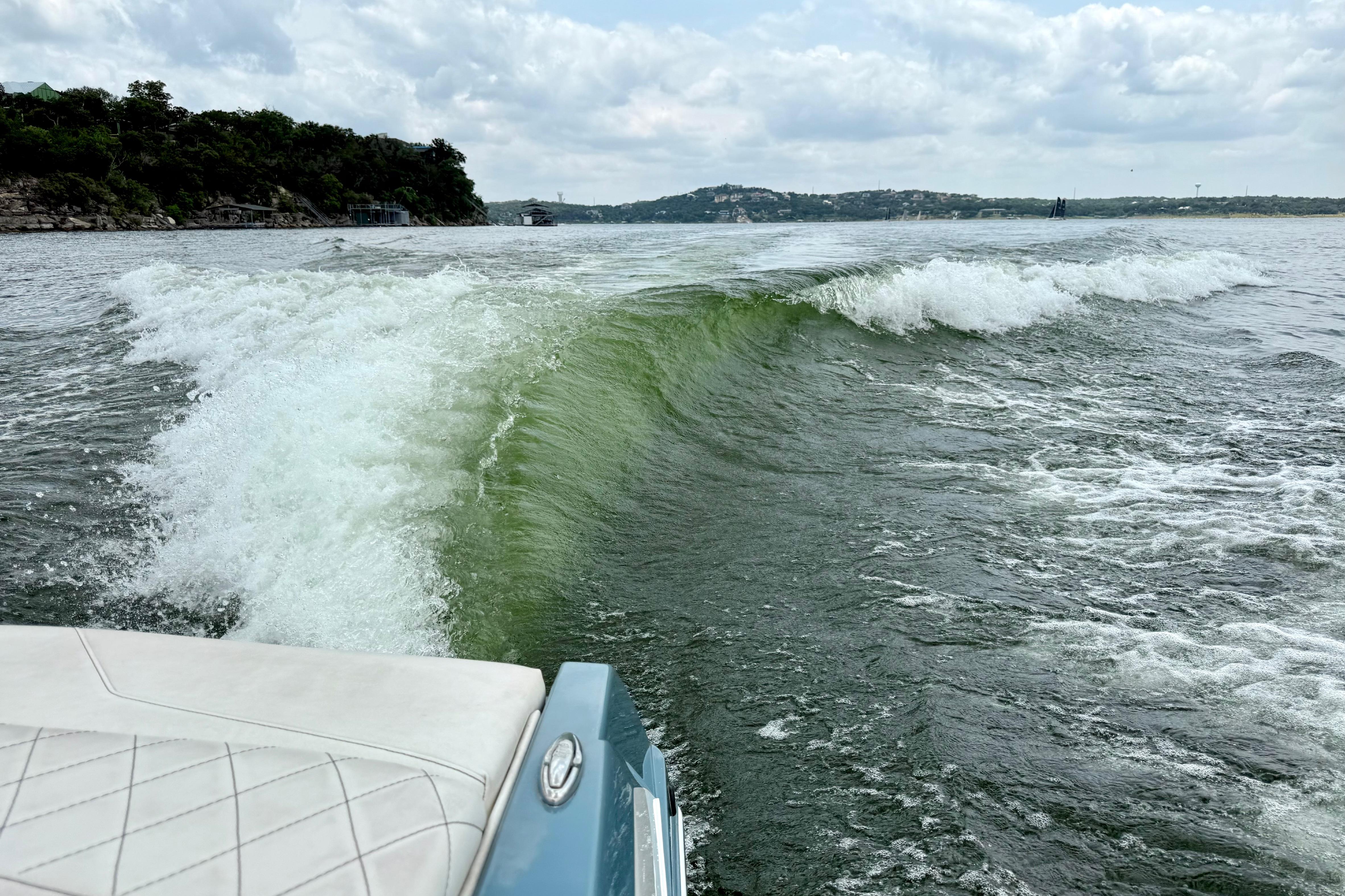 2021 Tige Z3 boat creating a large wake on a scenic lake.