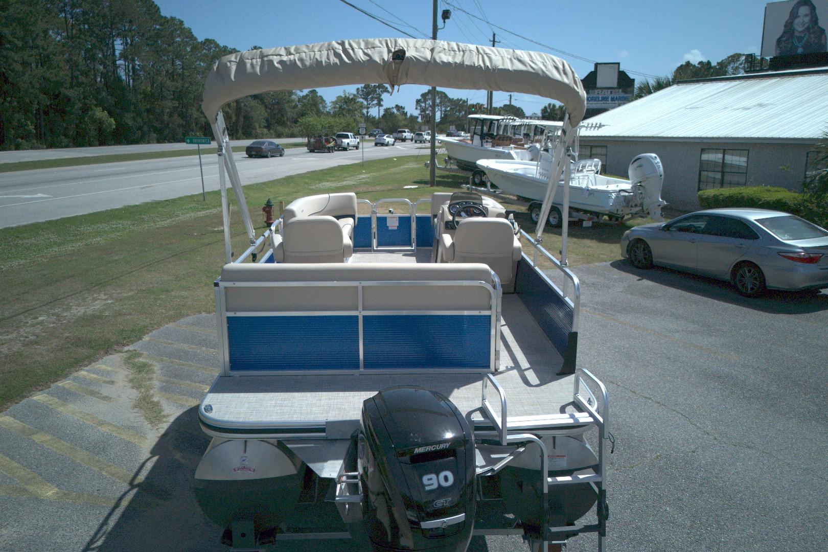 2024 Lowe Ultra 200 Cruise pontoon boat with canopy, parked near a road.