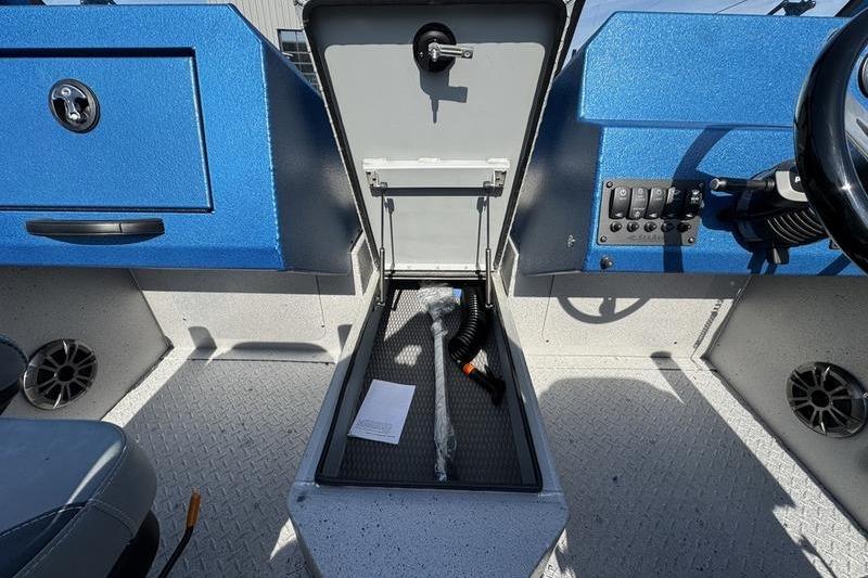 Interior of 2026 SeaArk Dynasty 2.0 boat showing storage compartment and control panel.