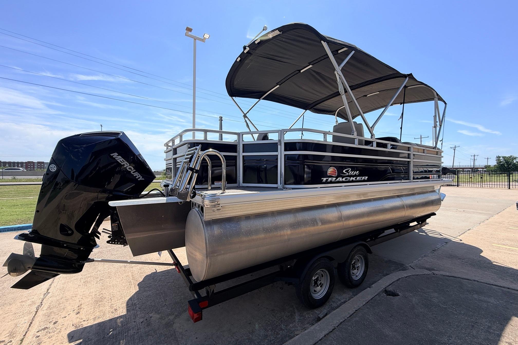 2024 Sun Tracker SportFish 22 XP3 pontoon boat with Mercury outboard engine on trailer.