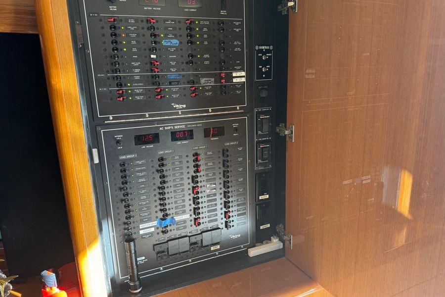 Electrical panel inside a 2002 Viking 61 Enclosed Bridge yacht, featuring various switches and controls.