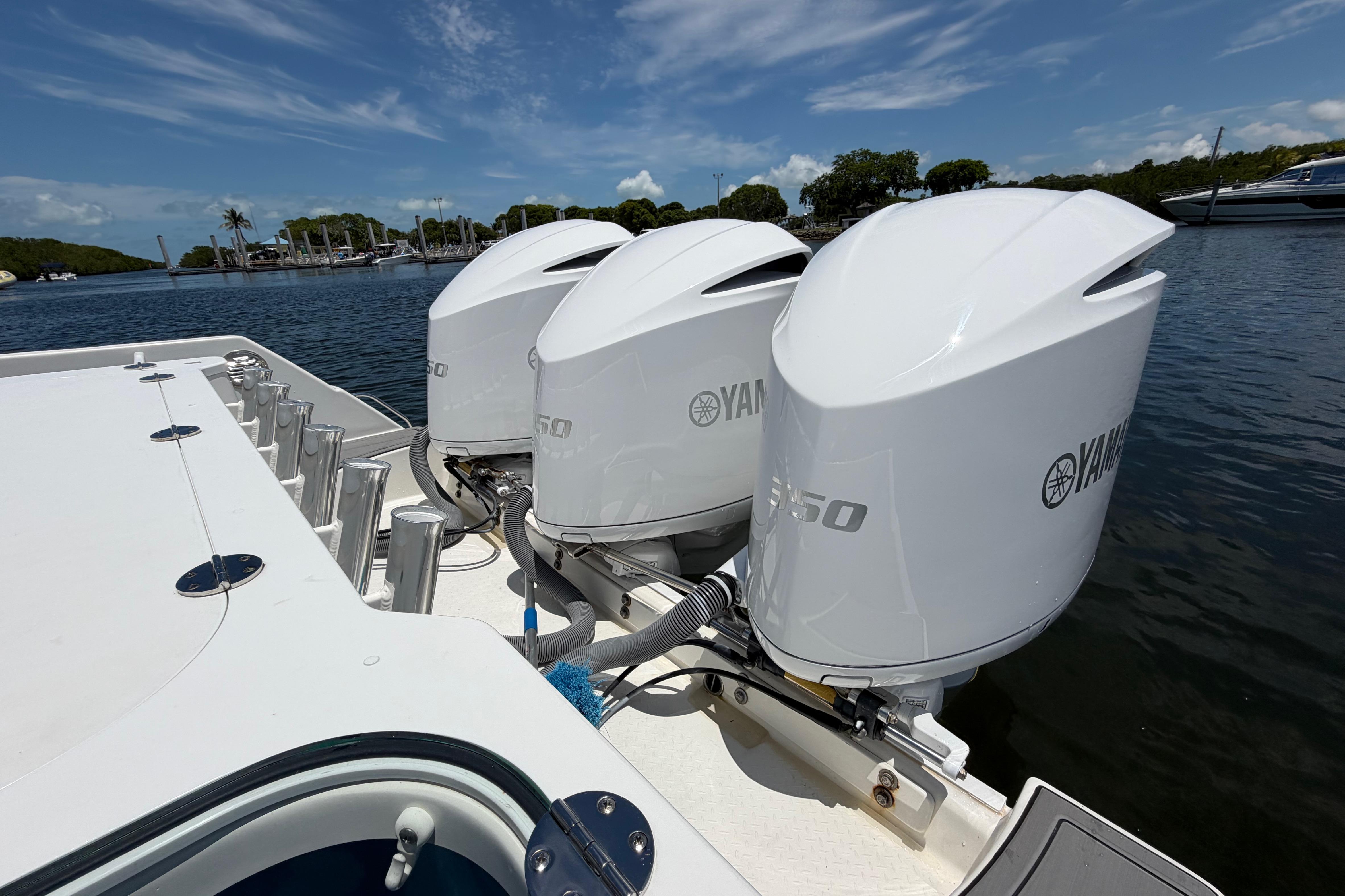 Triple Yamaha 350 engines on a 2009 Everglades 350LX boat, docked by the water.
