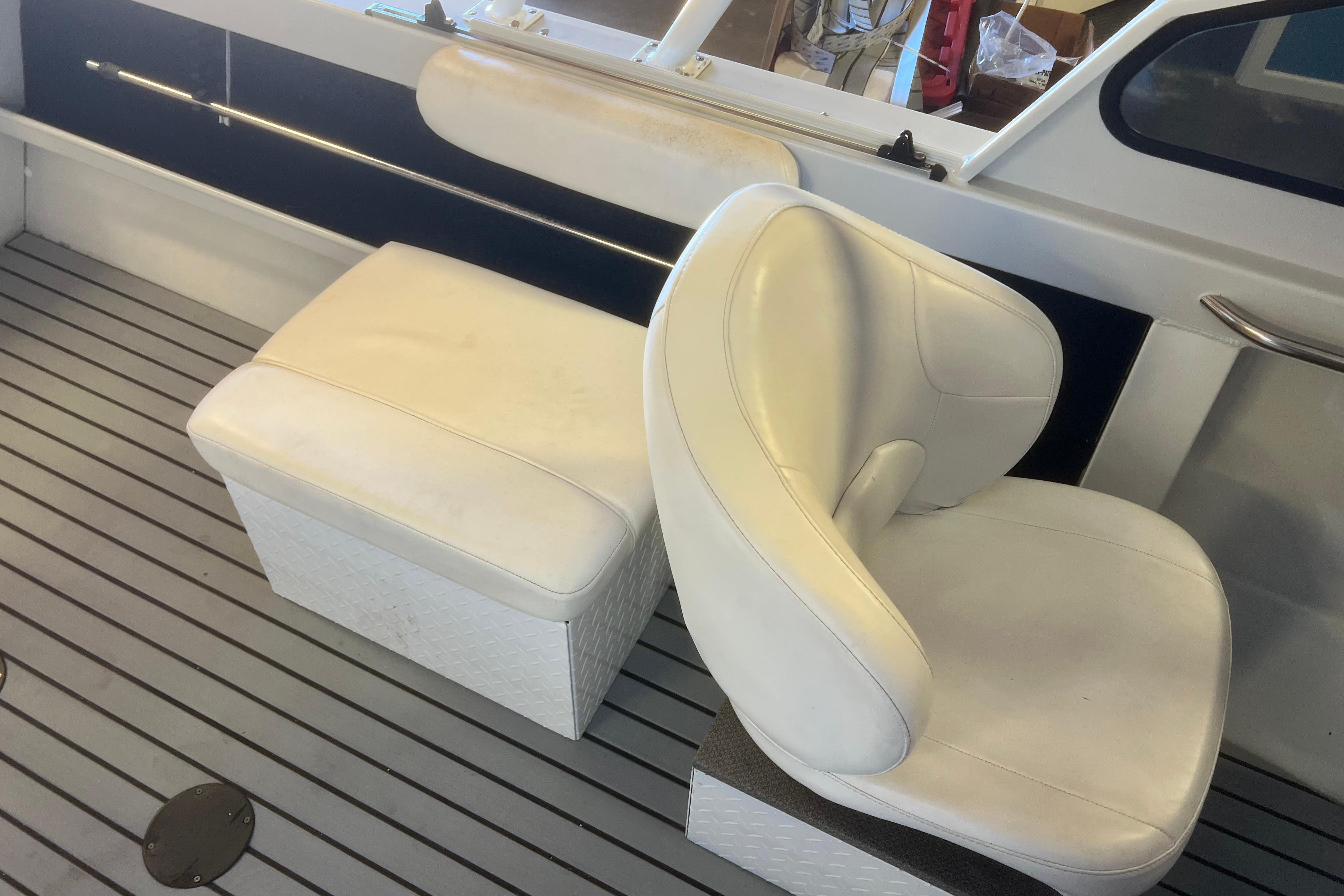 White seating on 2019 KingFisher 1825 Falcon boat, featuring cushioned chair and bench.