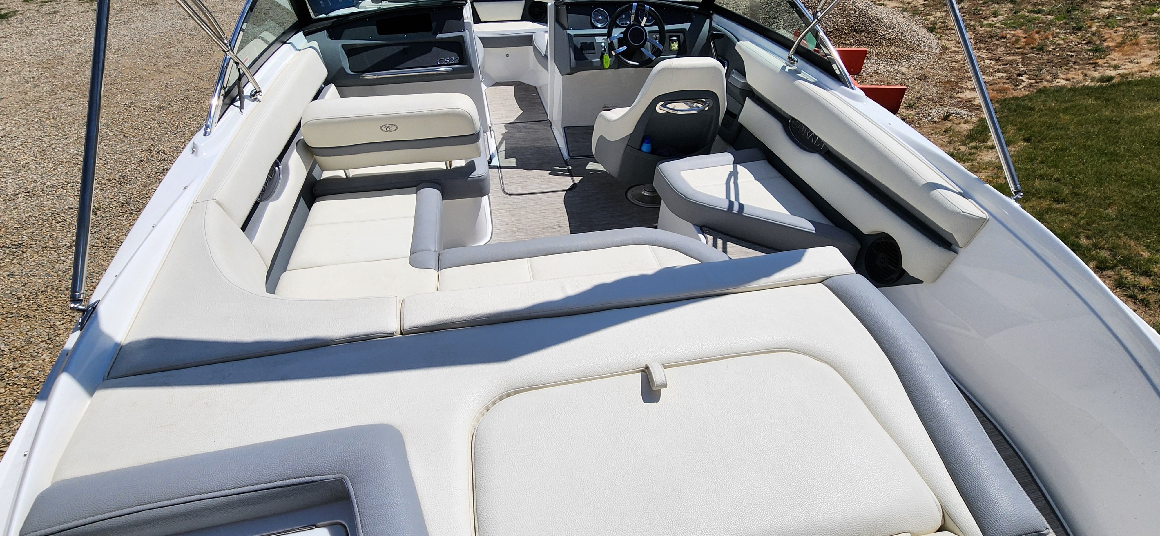 The image shows the interior of a Cobalt CS22 boat with white seating and a steering wheel.