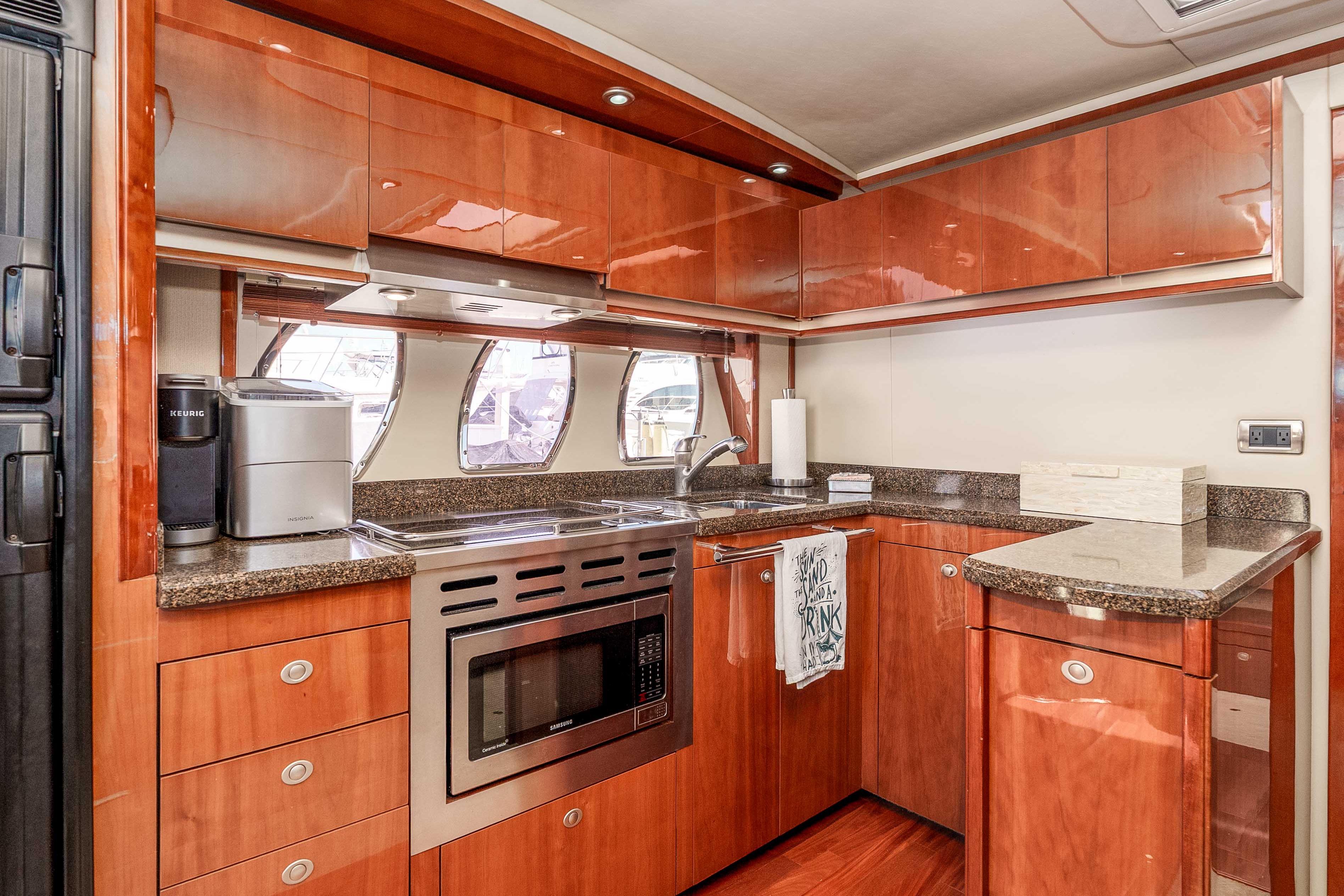 Luxurious 2007 Sea Ray 48 Sundancer yacht kitchen with modern appliances and wood cabinetry.