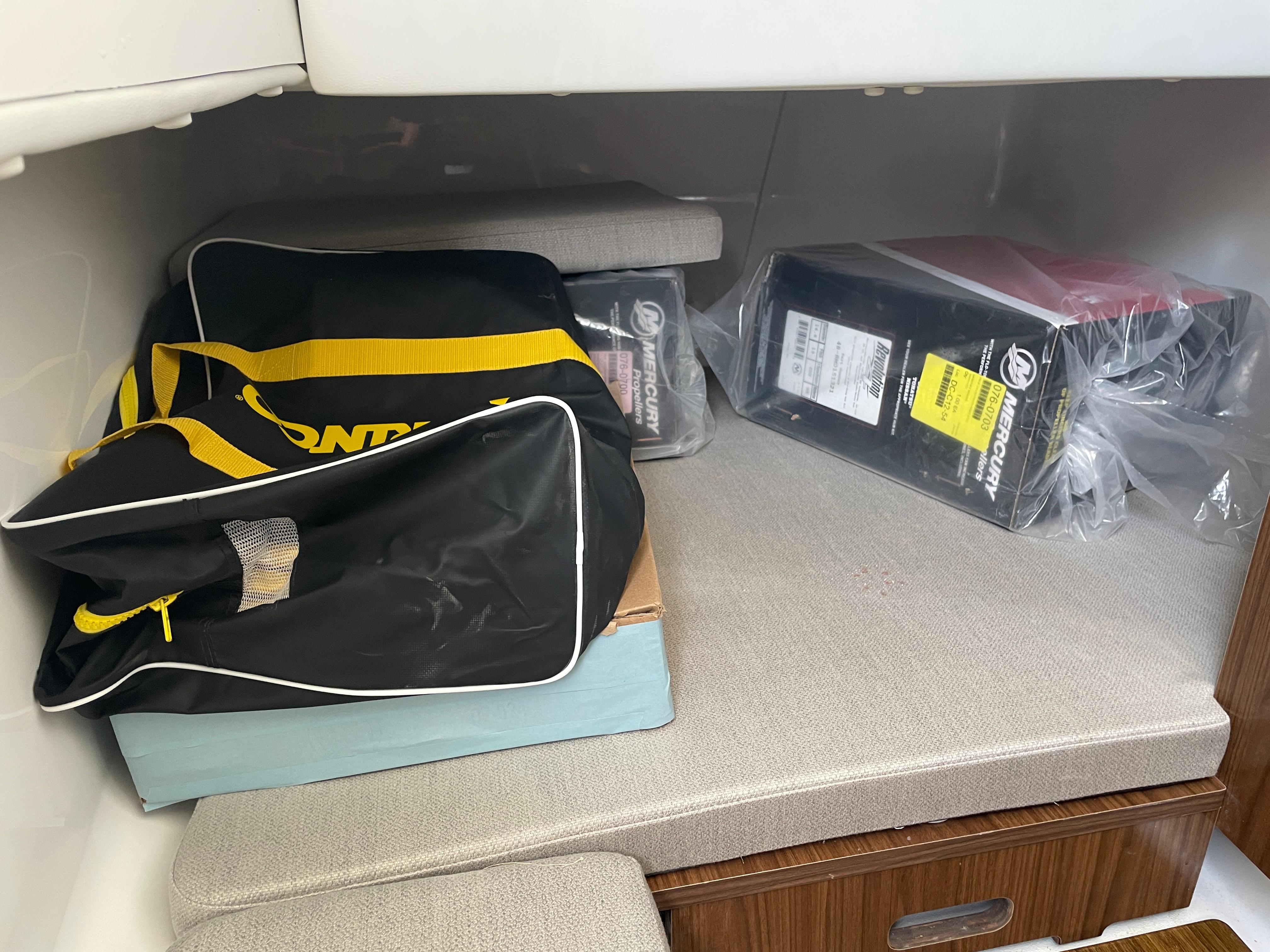 Interior storage area of 2023 Wellcraft 352 Fisherman with bags and boxes.