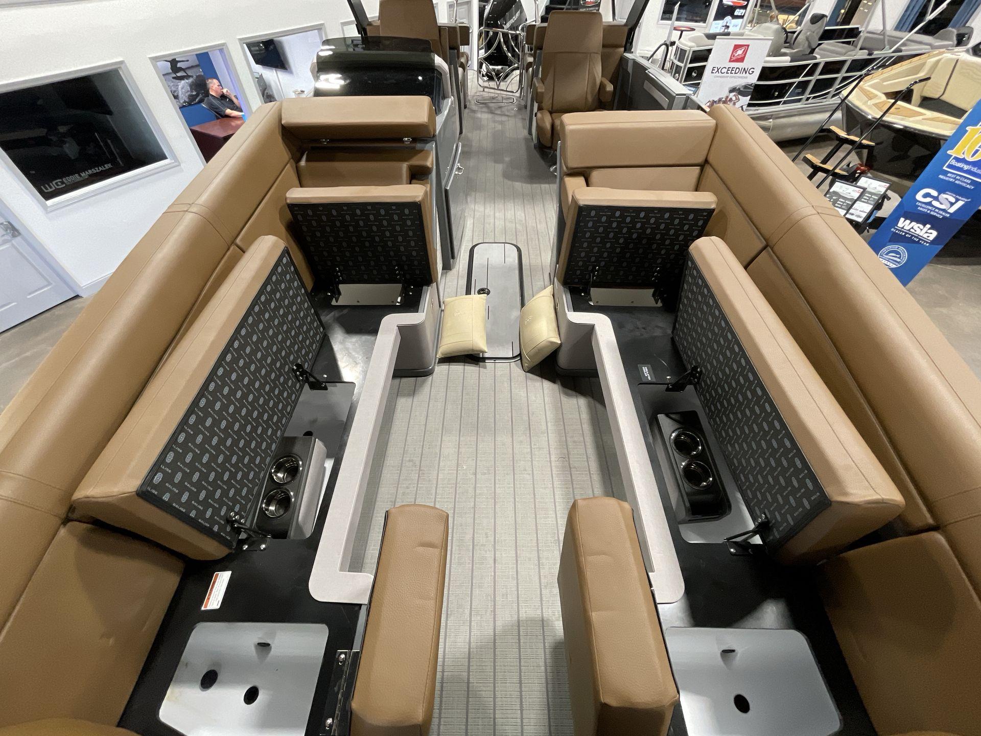 Interior of 2025 Balise Horizon 26C boat with tan seating and storage compartments.