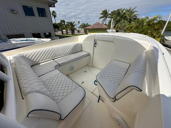 2005 Intrepid 323 boat interior with white quilted seating, docked near palm trees.