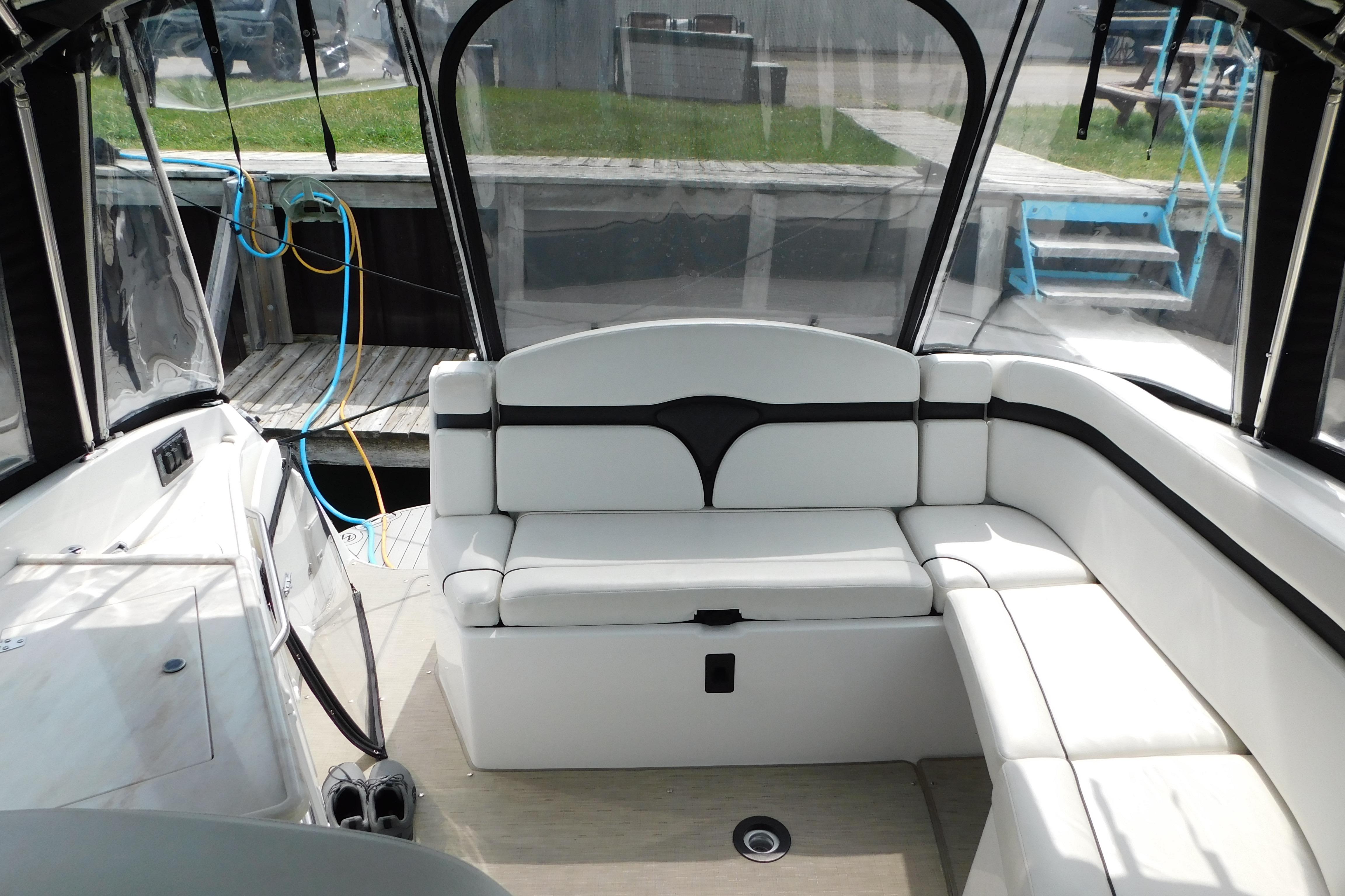 2017 Rinker EX 320 boat interior with white seating and clear canopy.
