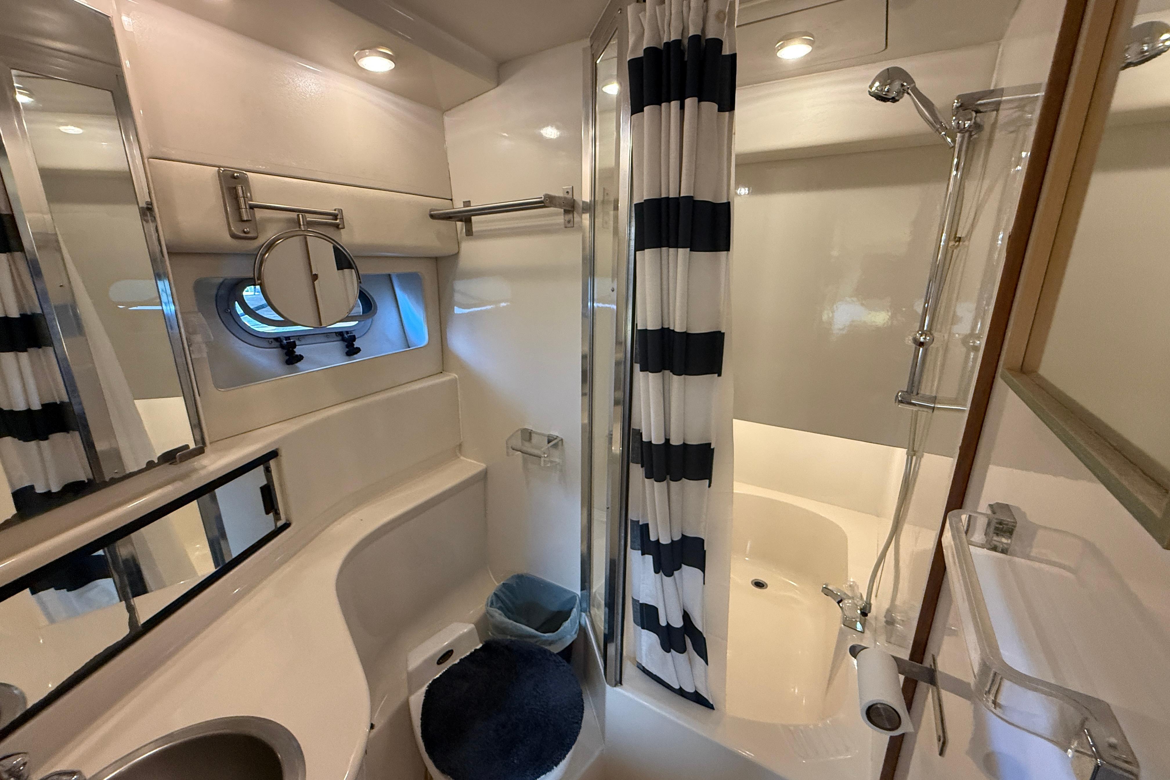 Bathroom of 1997 Bayliner 3988 Command Bridge Motoryacht with shower and striped curtain.