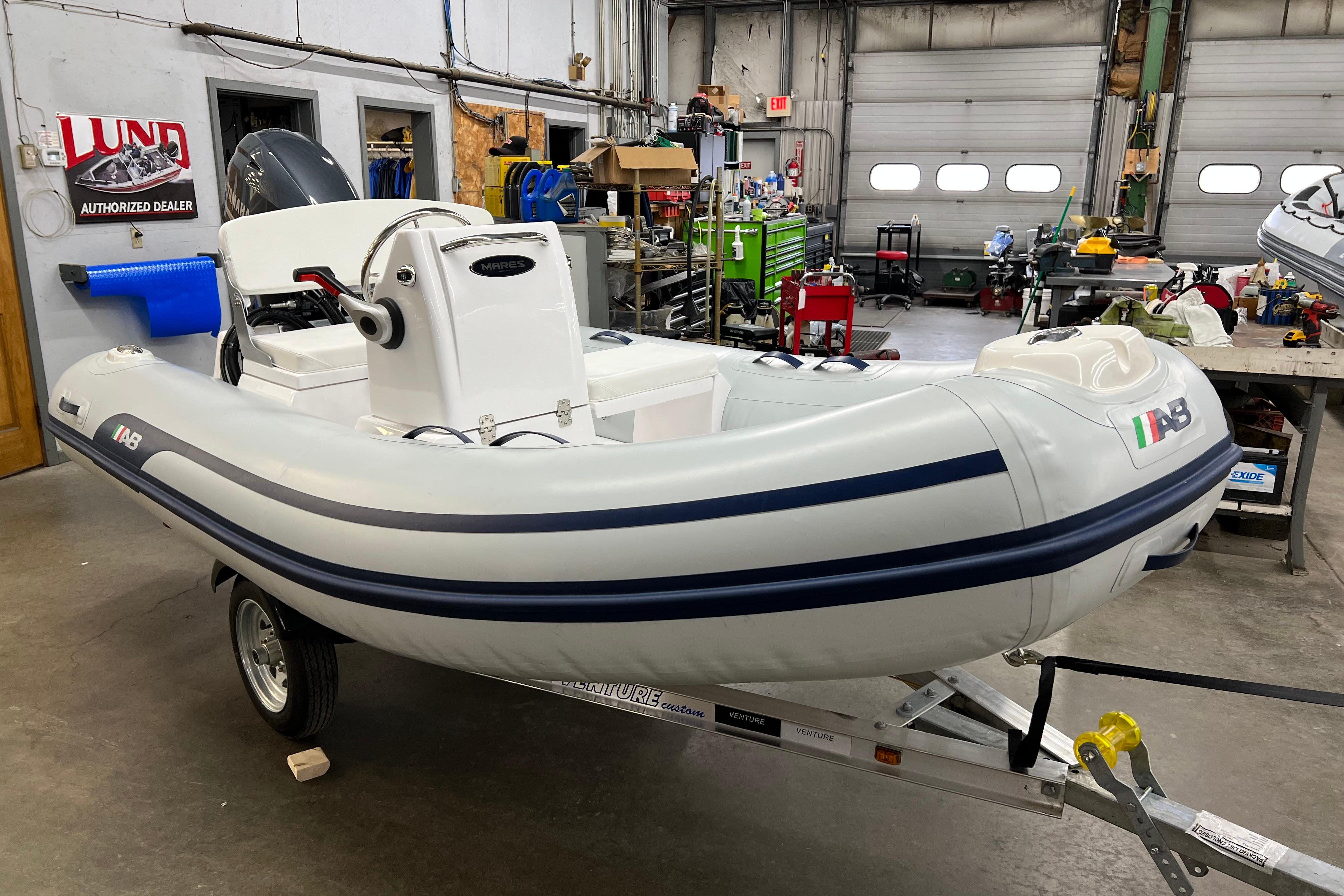 2023 AB Inflatables Mares 11 VSX boat on trailer in workshop setting.