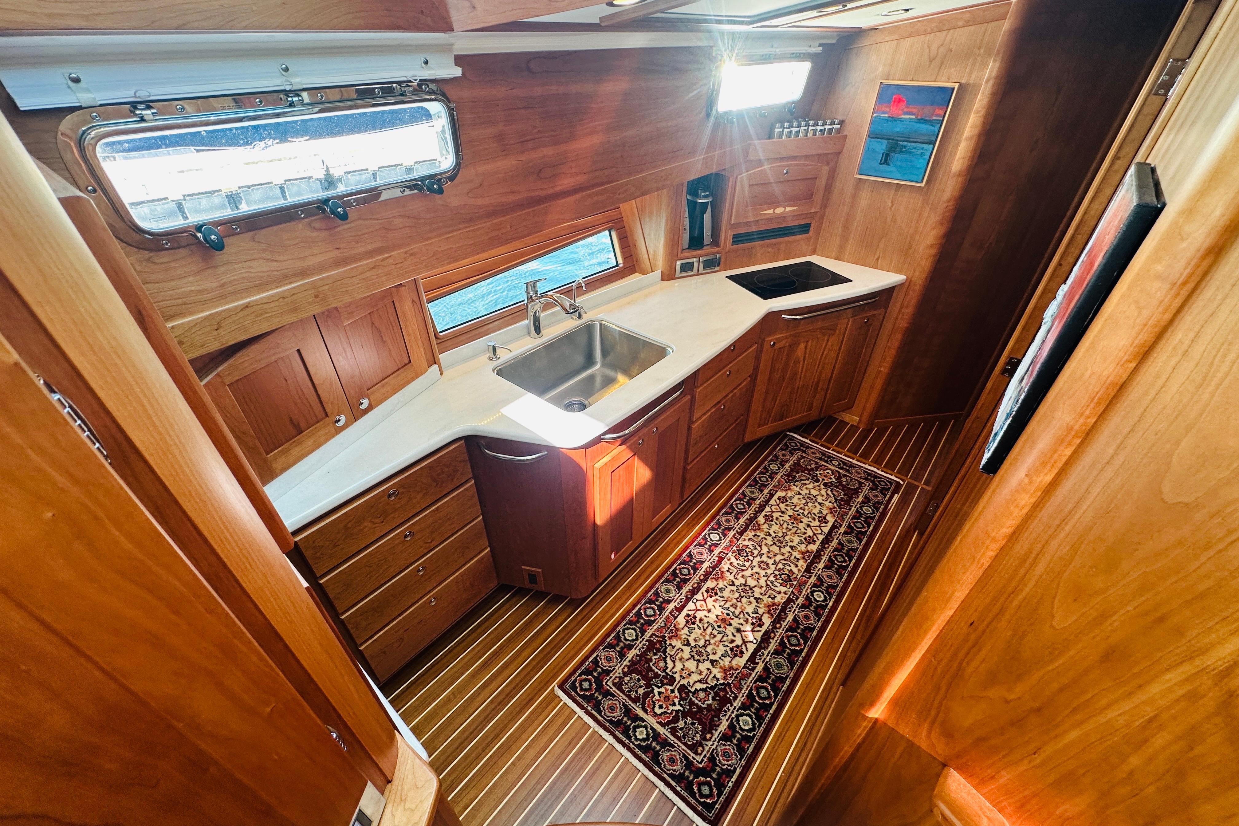 Luxurious 2025 Sabre 48 Salon Express yacht interior with elegant wooden cabinetry and modern kitchen.