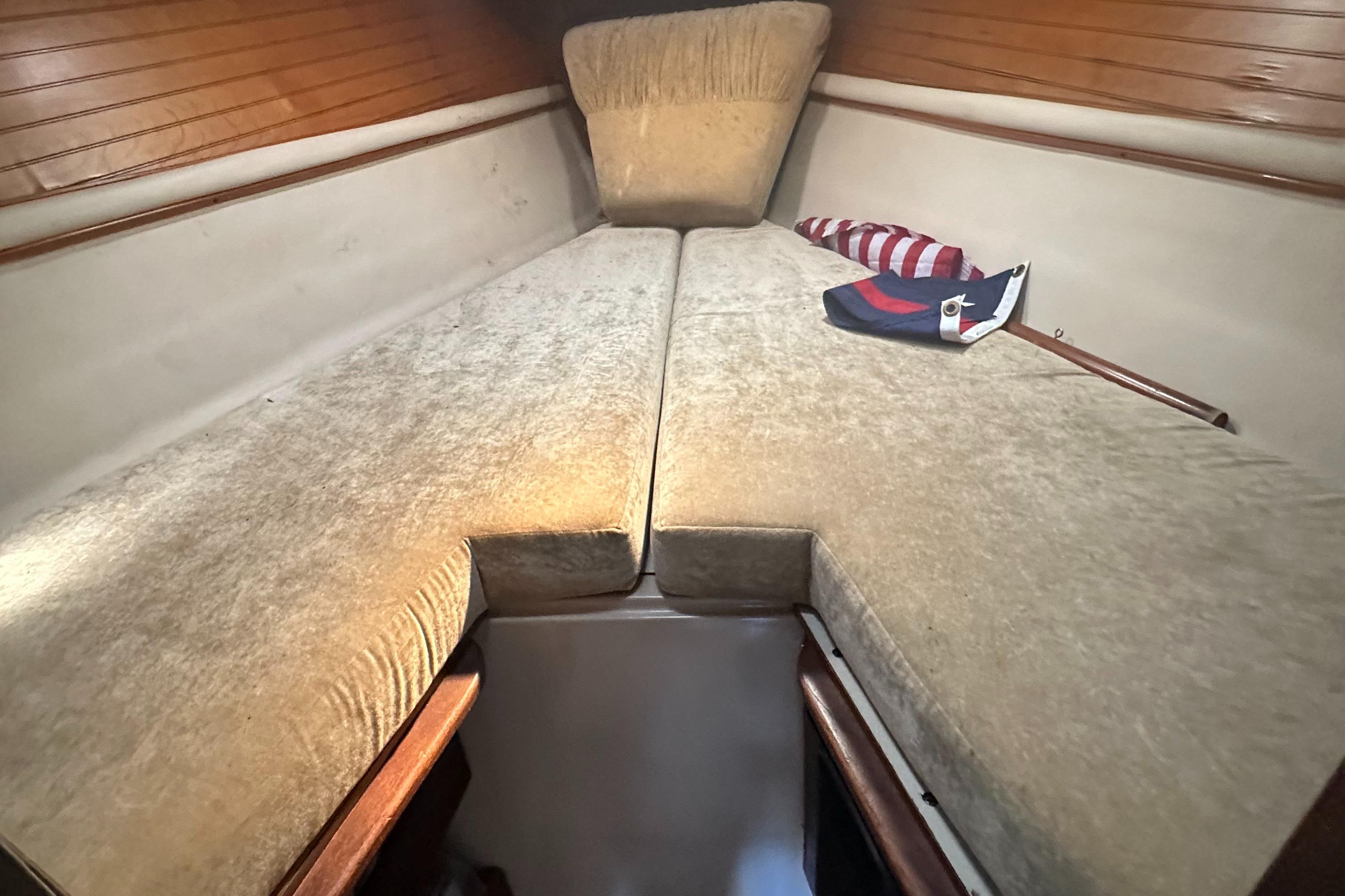 Interior cabin of 1983 O'Day 28 sailboat with beige cushions and wooden accents.