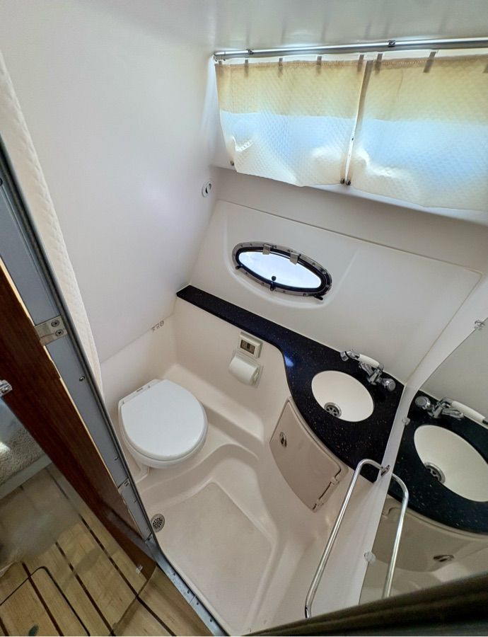 Bathroom in a 2014 Regal 30 Express boat with toilet, sink, and window.