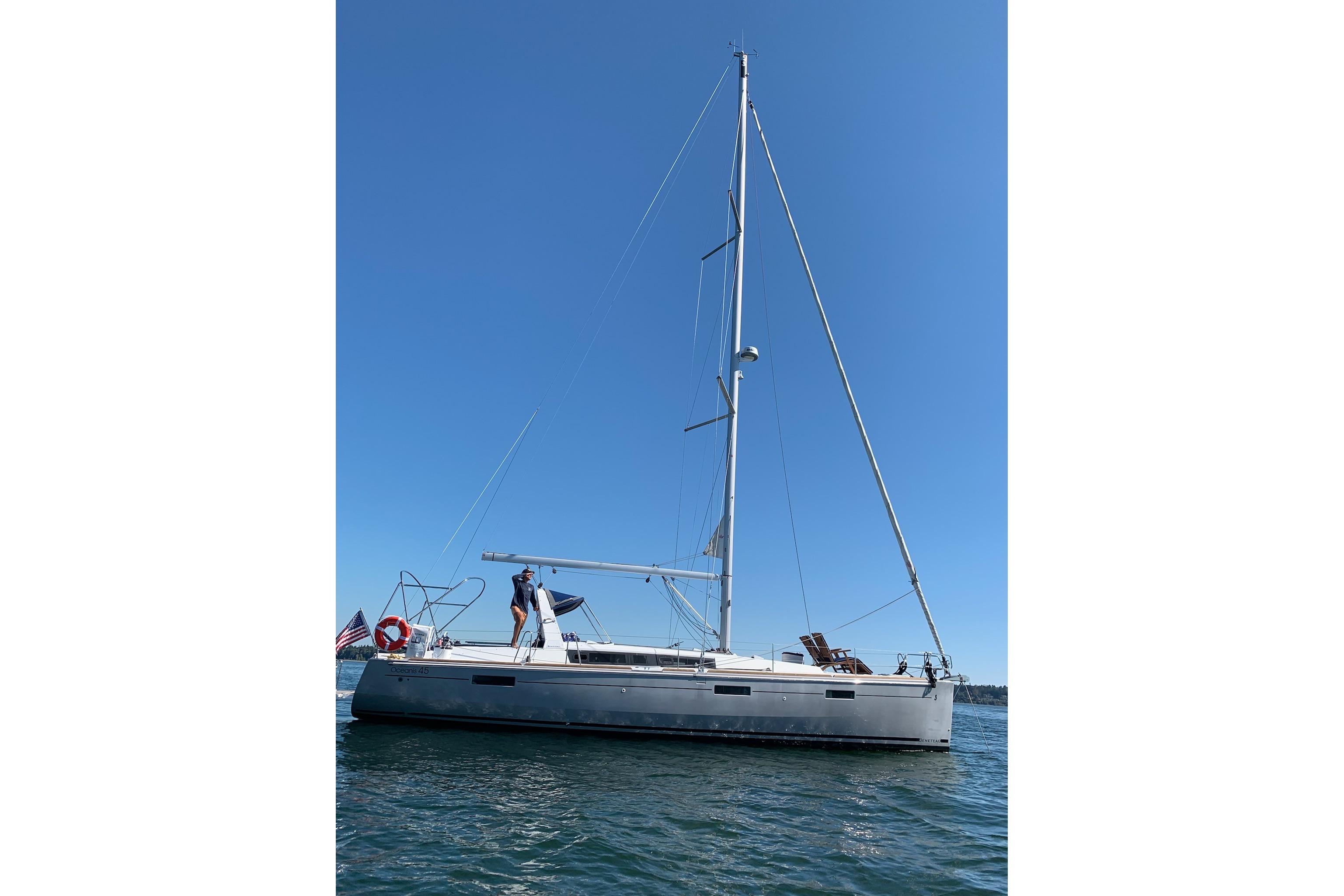 2018 Beneteau Oceanis 45 sailboat on calm water under clear blue sky.