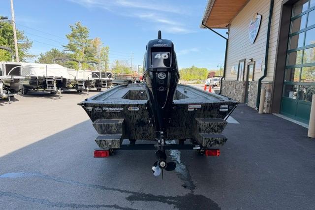 2026 Tracker Grizzly 1654 T Sportsman boat with 40 HP motor, parked outside dealership.