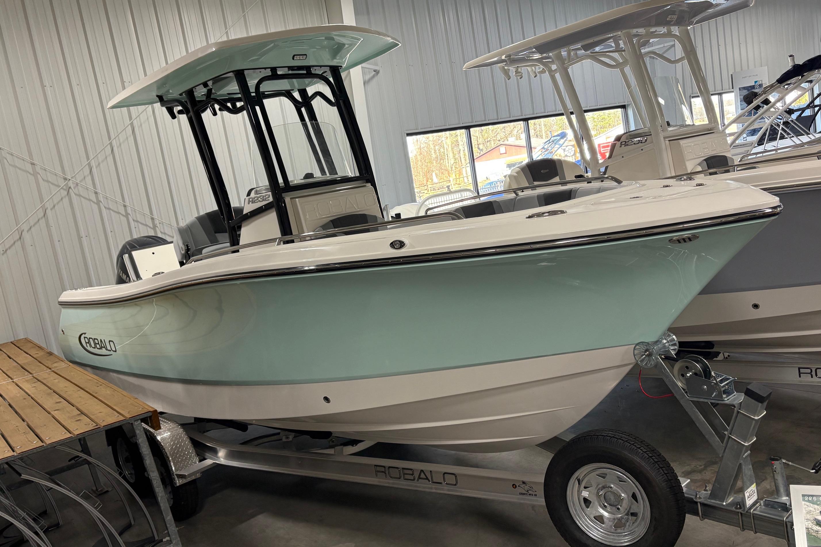 2025 Robalo R232 Explorer boat displayed indoors on a trailer.