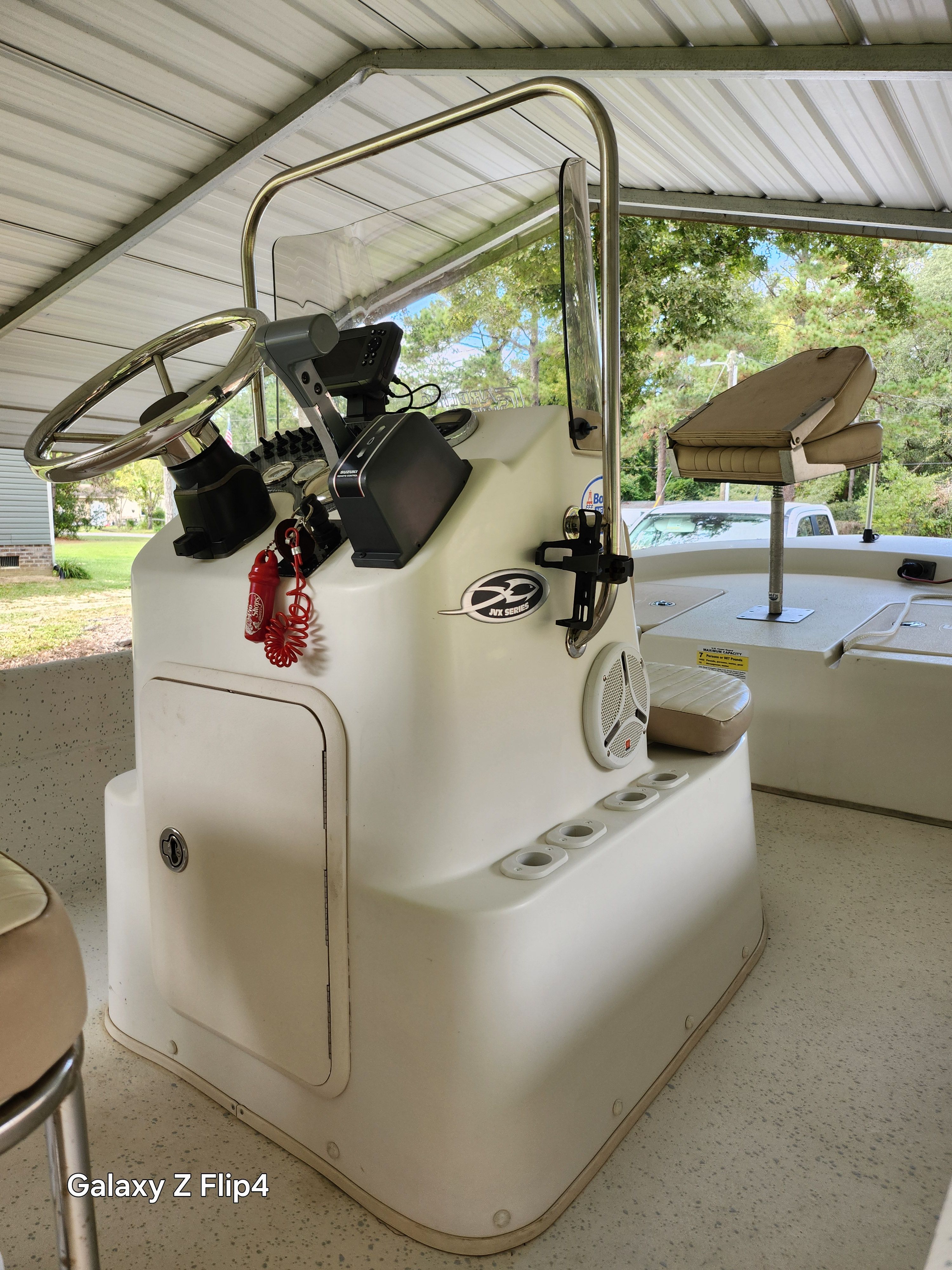 2013 Carolina Skiff JVX18CC boat console under a metal canopy.