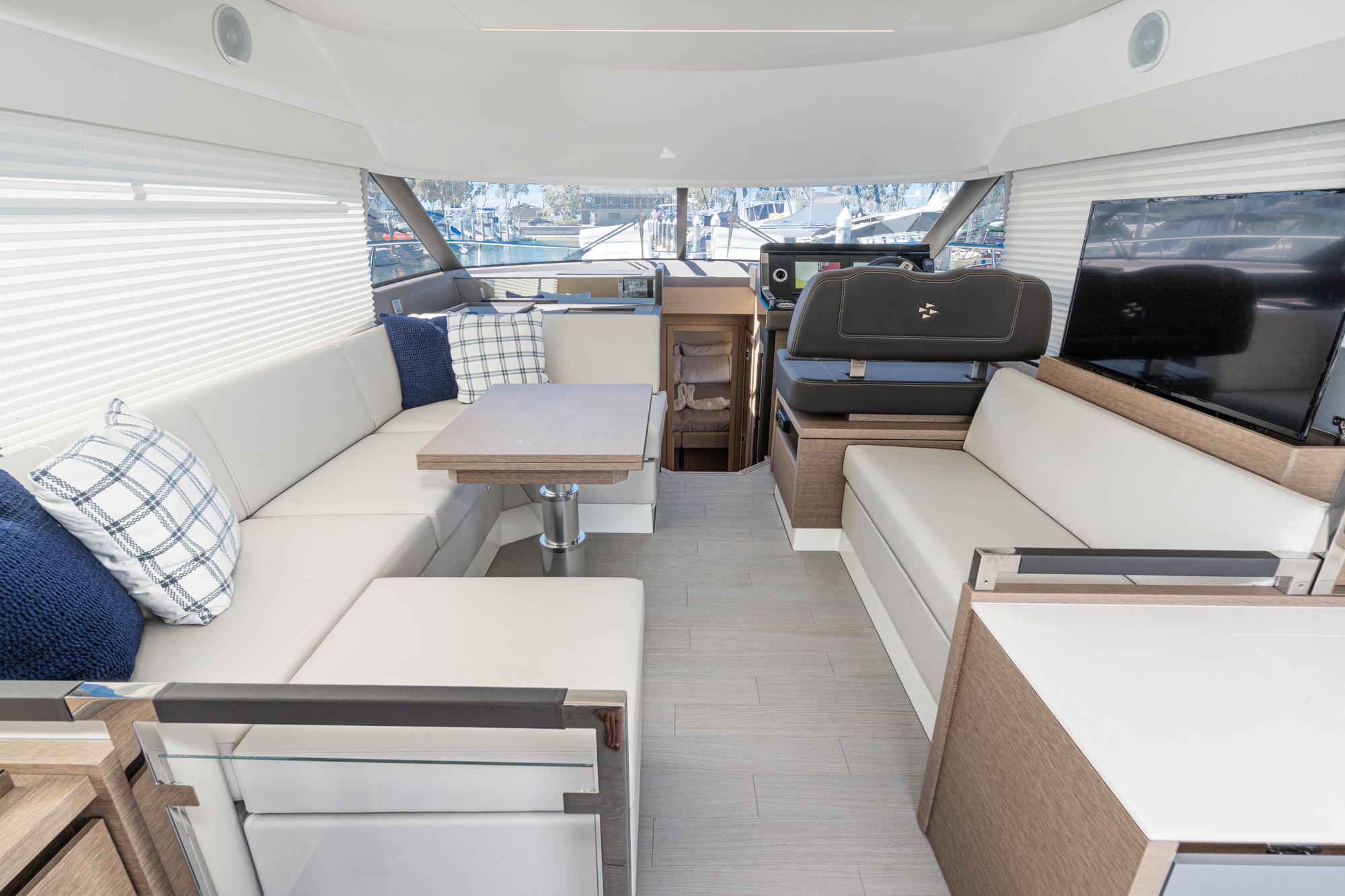 Luxurious interior of 2022 Prestige 460 yacht with modern seating and dining area.