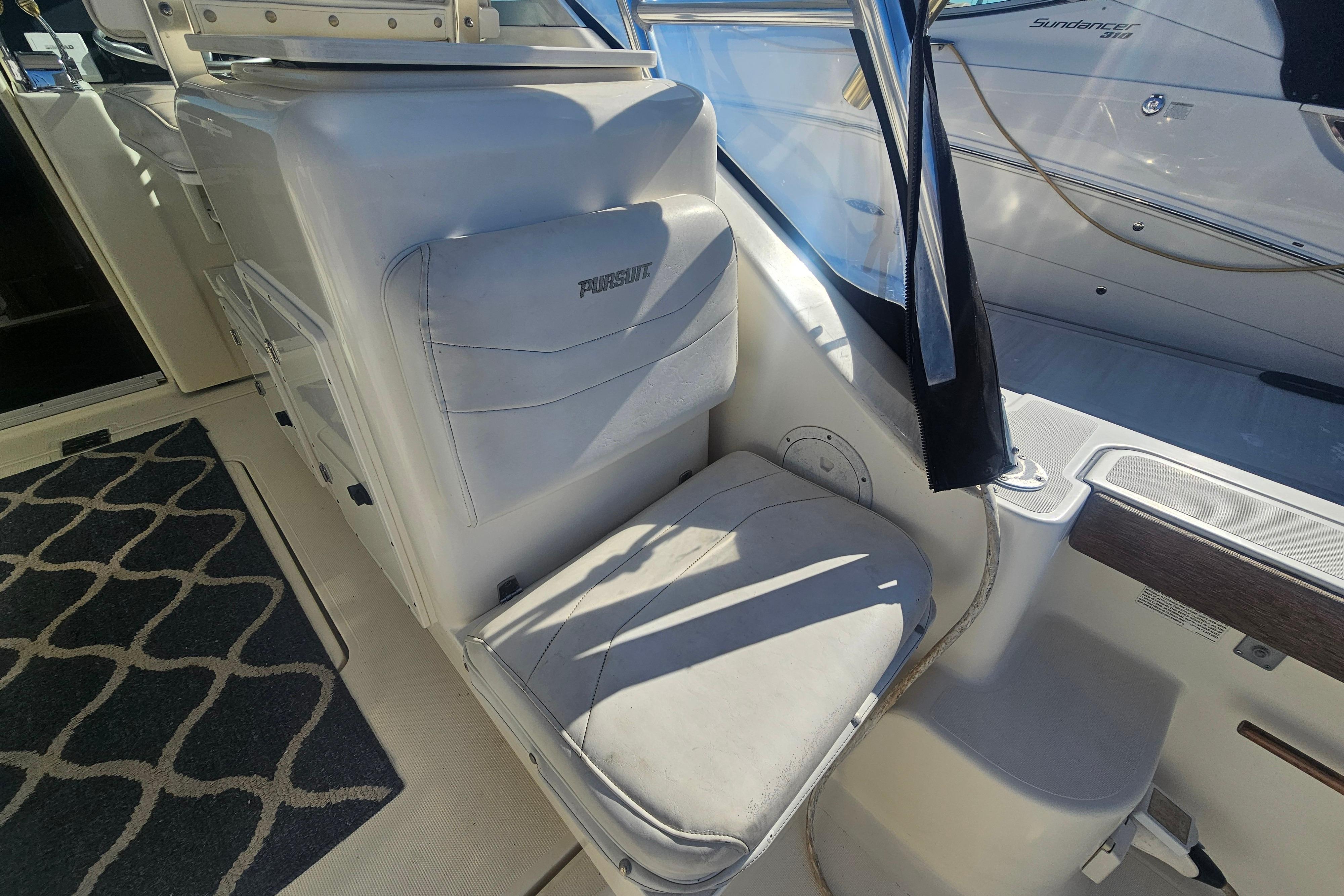 2001 Pursuit 3000 Express boat interior with cushioned seating and nautical decor.