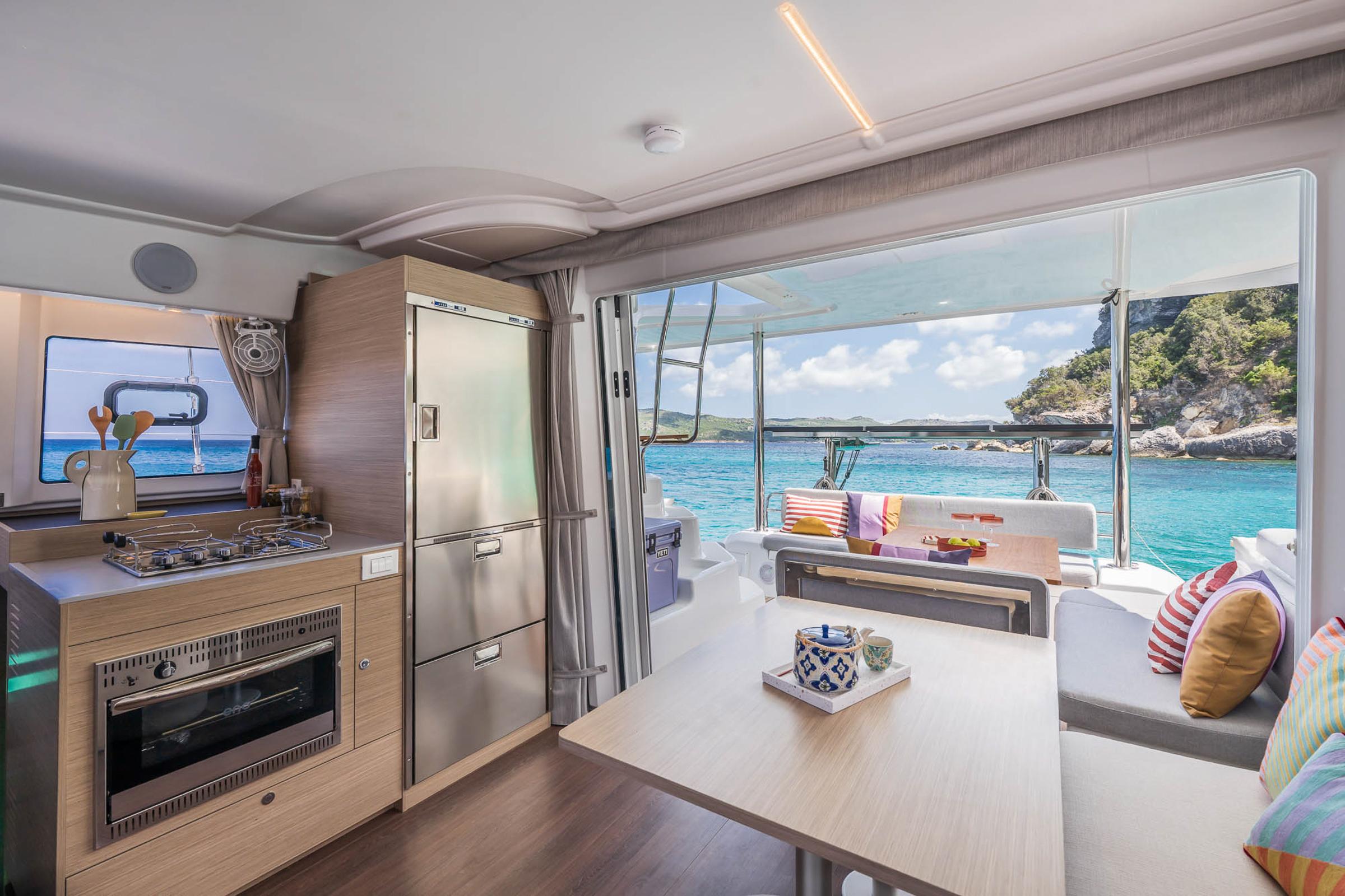 Modern interior of 2025 Lagoon 38 catamaran with kitchen and ocean view.