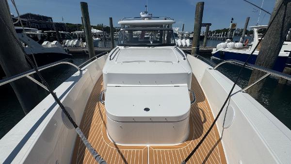 2025 Nimbus T11 boat docked, featuring sleek white design and spacious deck.