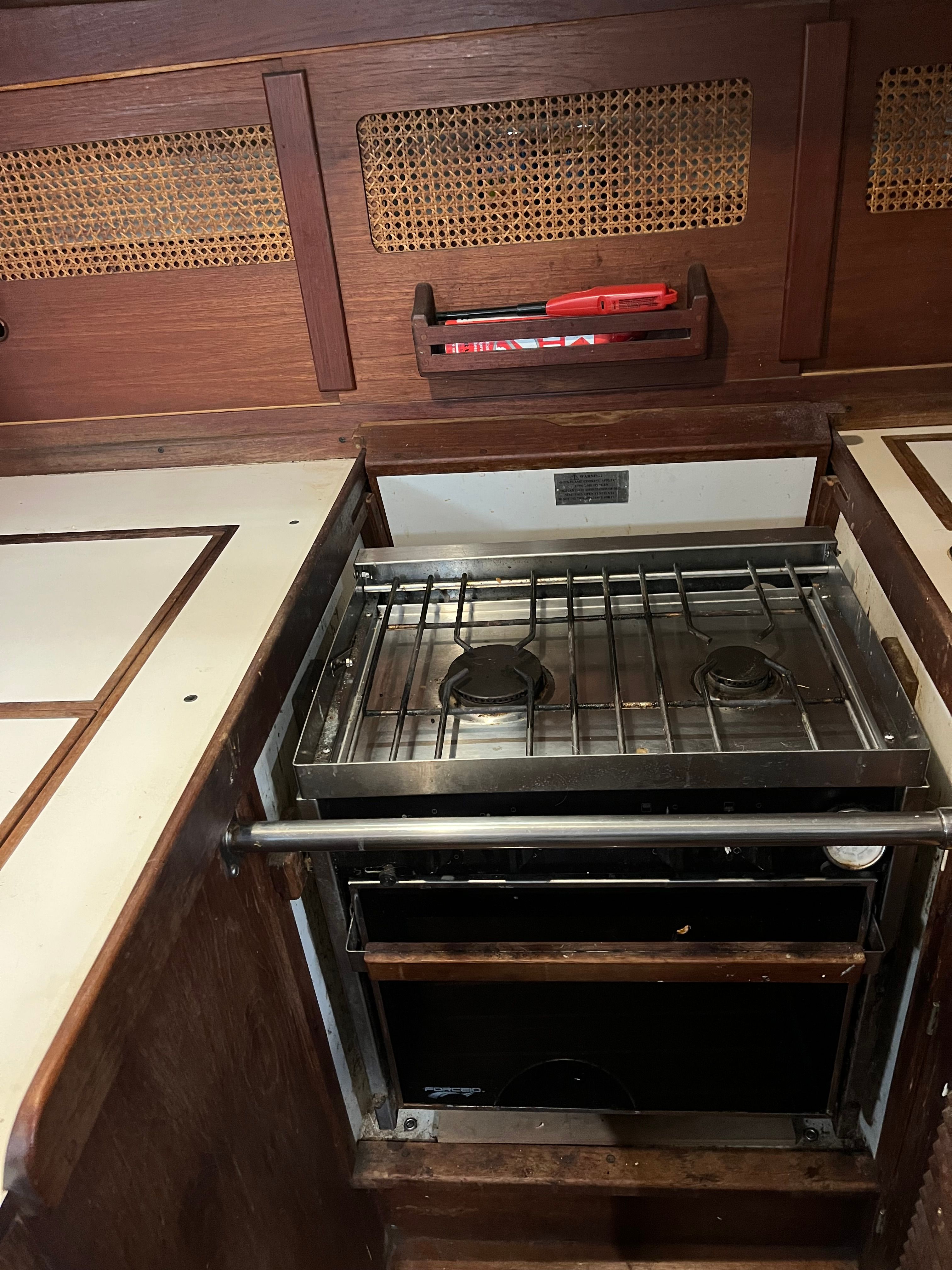 Interior of a 1981 Tartan Sloop featuring a stove and wood paneling.