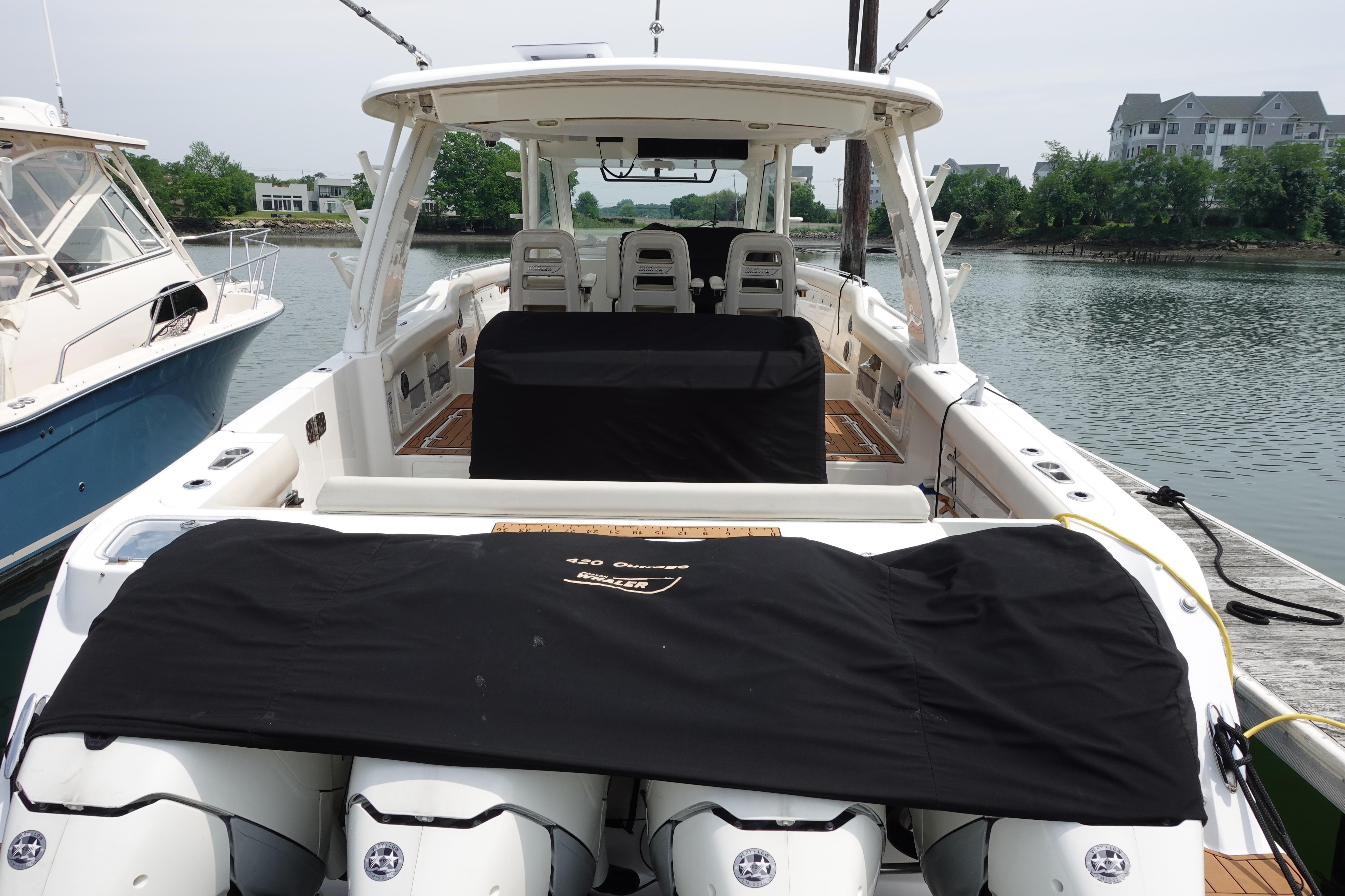 2020 Boston Whaler 420 Outrage docked, showcasing spacious deck and covered engines.