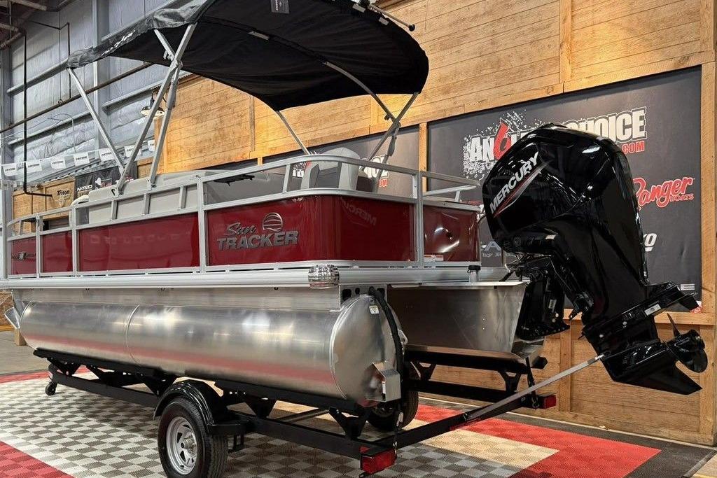 2026 Sun Tracker Bass Buggy 18 DLX pontoon boat with Mercury engine in showroom.