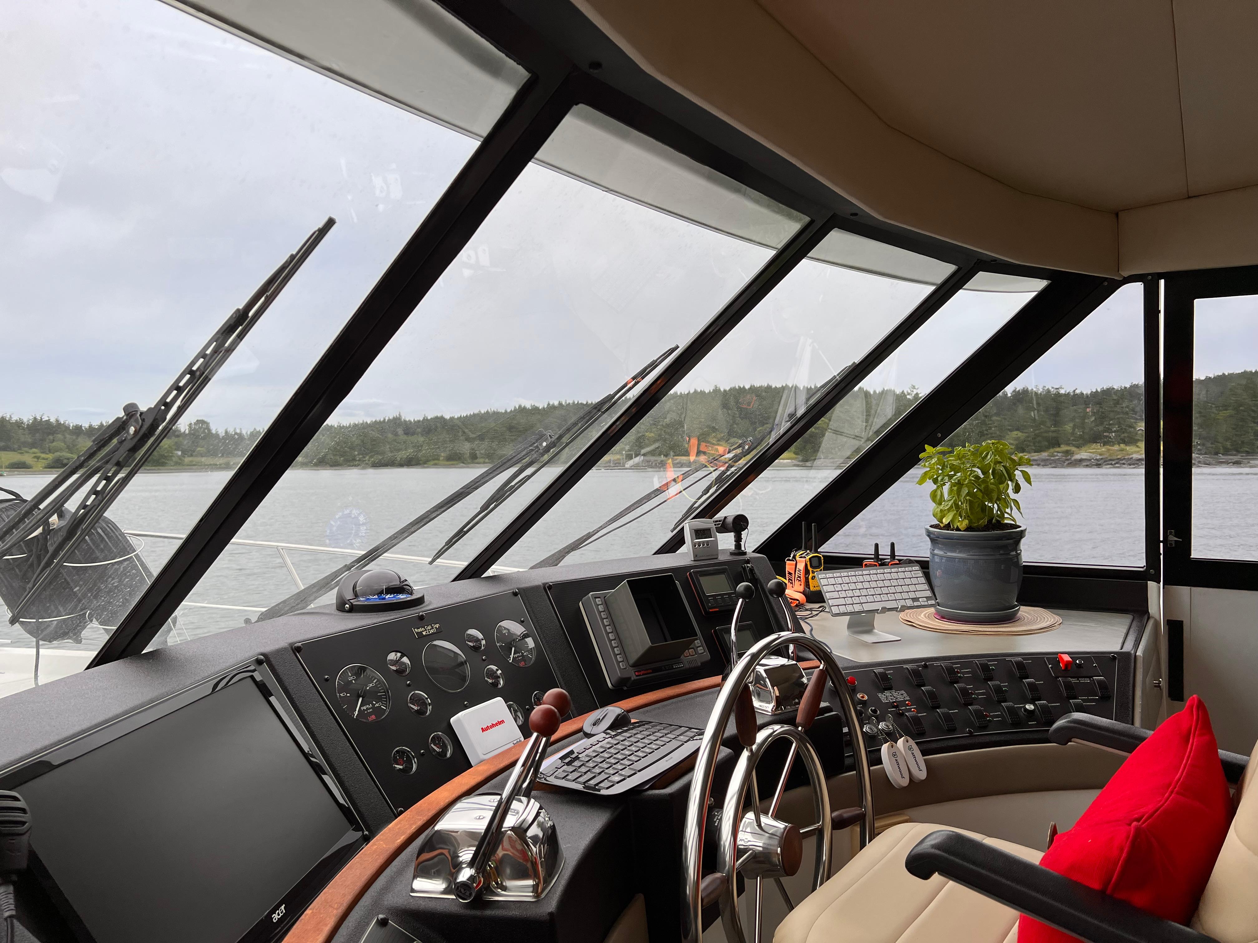 1994 Bayliner 4788 Pilot House Motoryacht interior with steering wheel and panoramic windows.