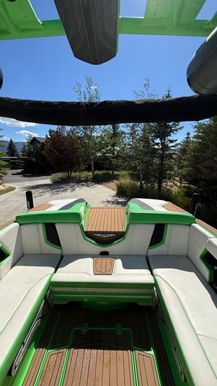 The image shows the stern of a 2018 Nautique Super Air Nautique G23 with green accents.