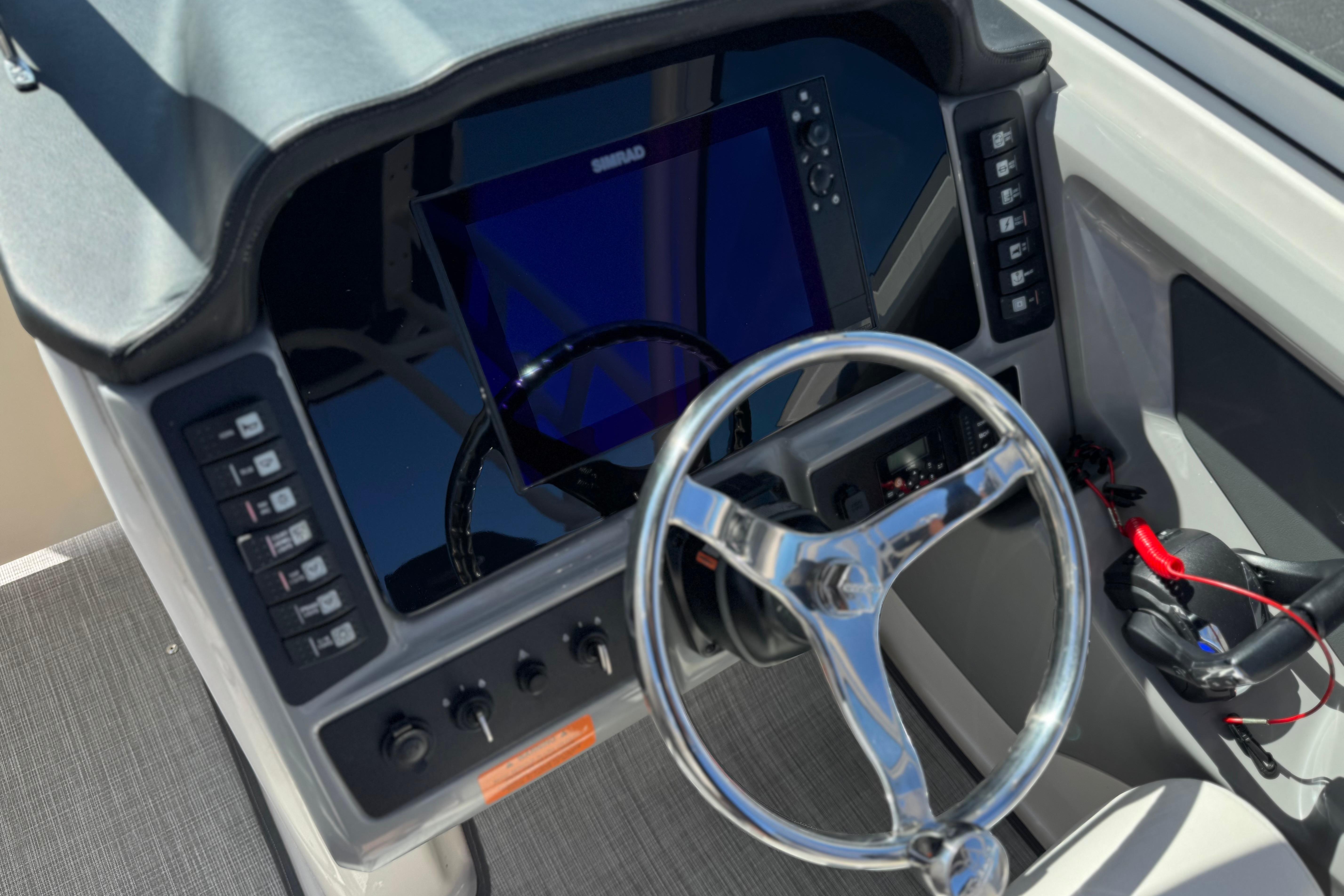 2022 Robalo R247 Dual Console boat dashboard with steering wheel and control panel.