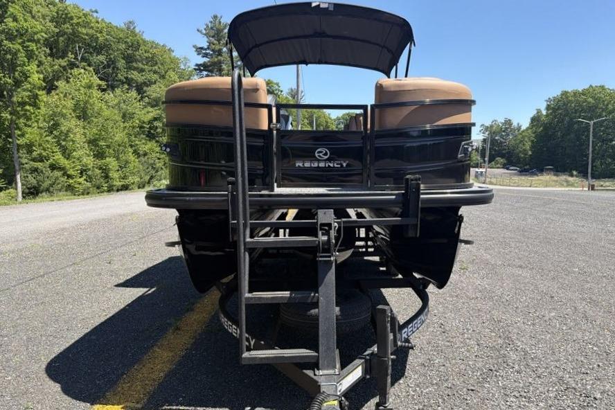 2026 Regency 230 DL pontoon boat on trailer, parked on a sunny road.