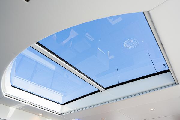 2021 Riviera 5400 Sport Yacht panoramic sunroof, blue sky view.