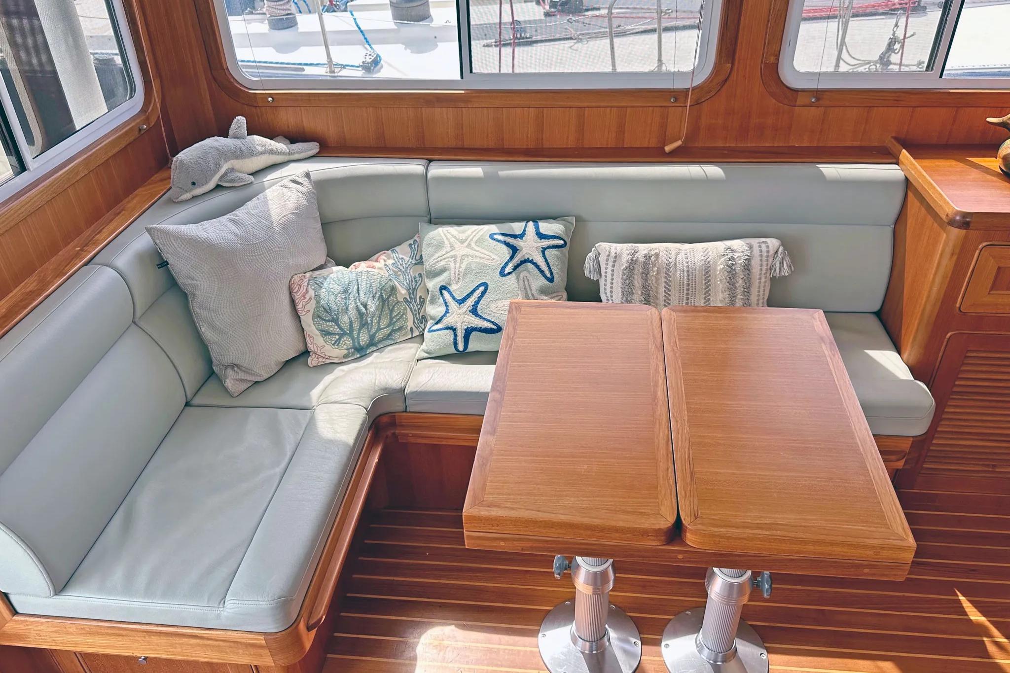 Cozy interior of 2016 Helmsman Trawlers 38 Pilothouse with plush seating and decorative pillows.
