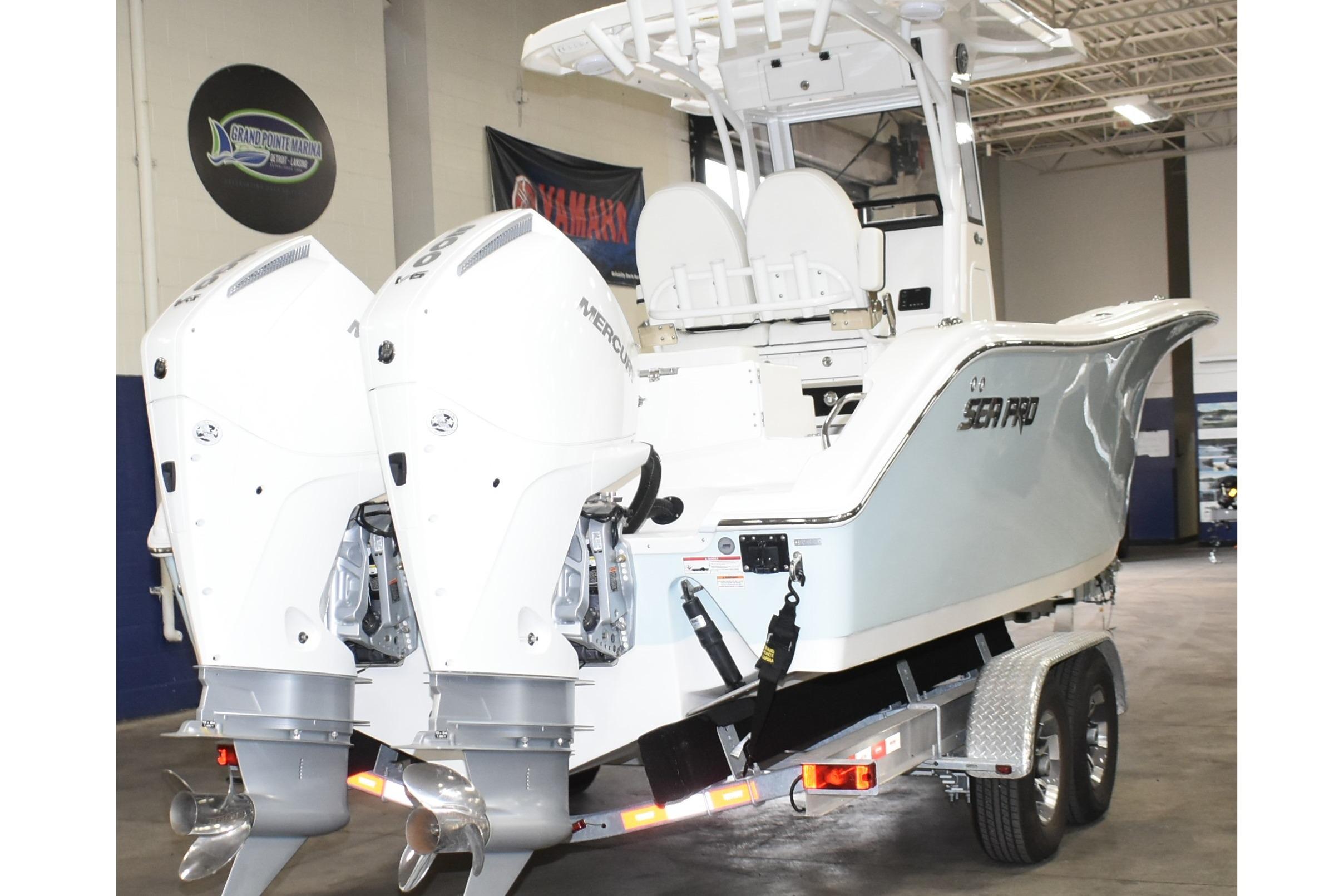 2025 Sea Pro 262 Offshore boat with dual Mercury engines on a trailer in a showroom.
