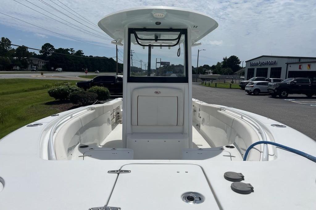 2021 Sea Hunt Gamefish 25 boat, white interior, parked near a showroom.