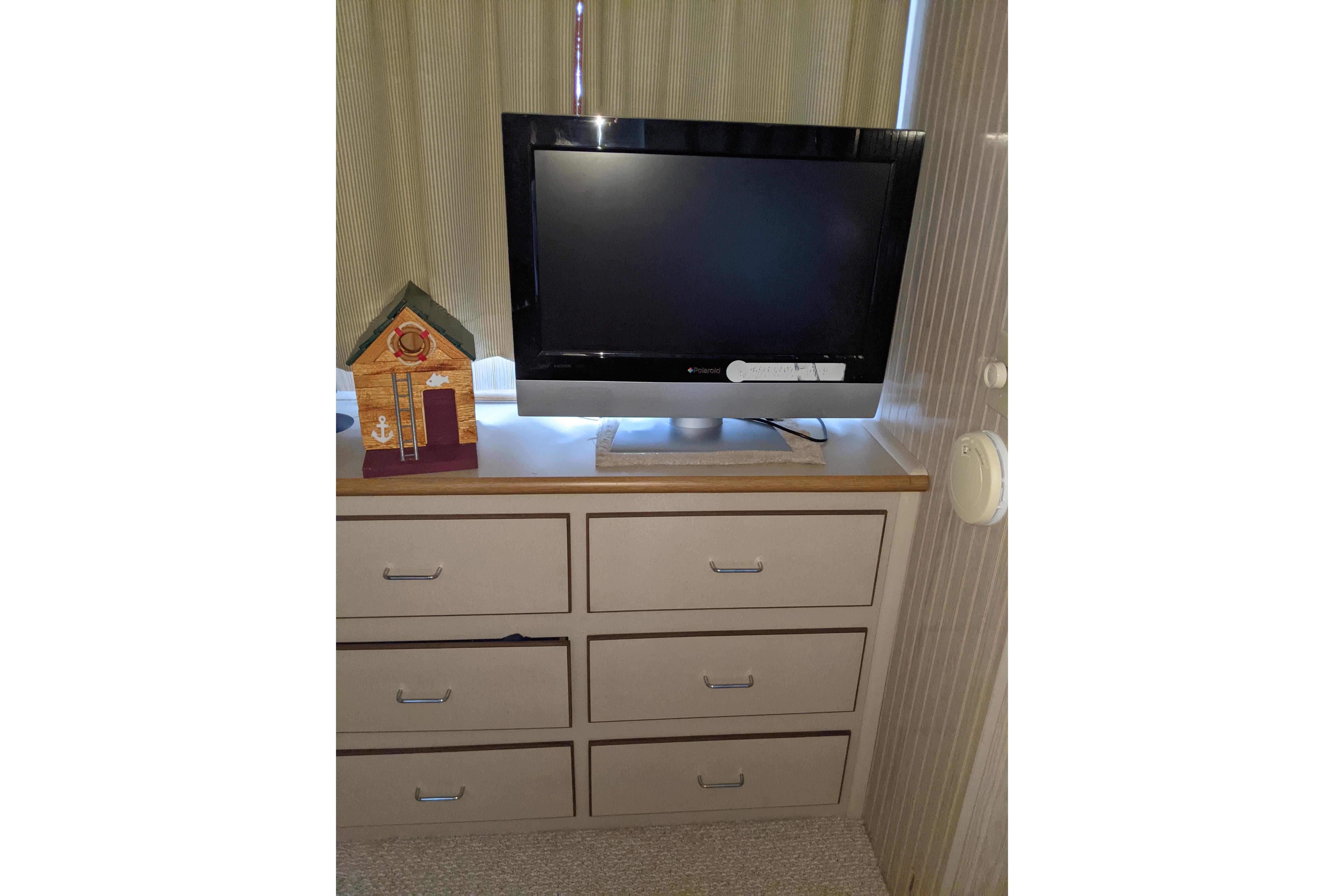 TV and decorative house on dresser inside 2001 Gibson 50 Cabin Yacht.