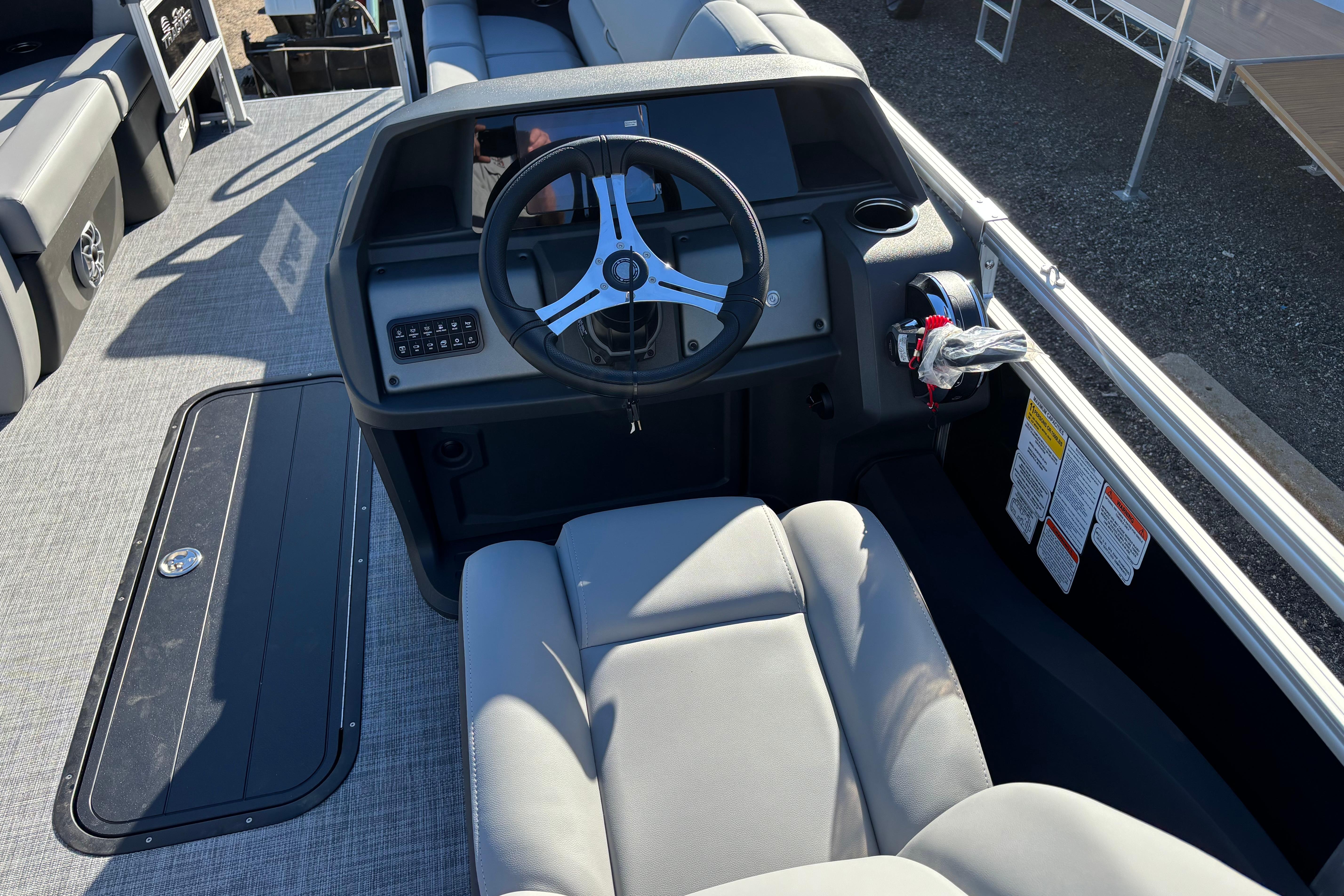 2026 Sun Tracker SportFish 22 XP3 boat interior with steering wheel and seating.