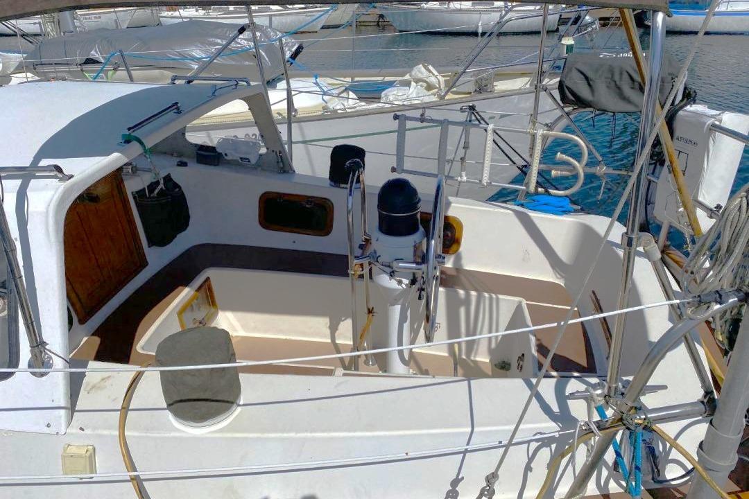 1983 Fraser 41 sailboat cockpit with steering wheel, docked at marina.