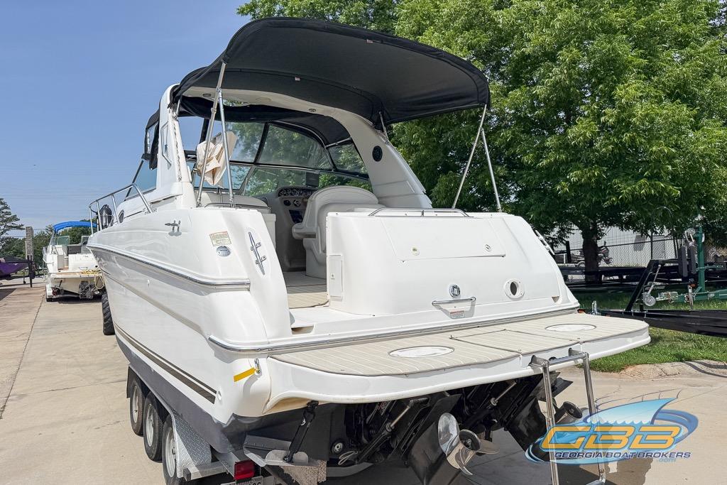 1999 Sea Ray 290 Sundancer boat on trailer, featuring spacious deck and canopy.