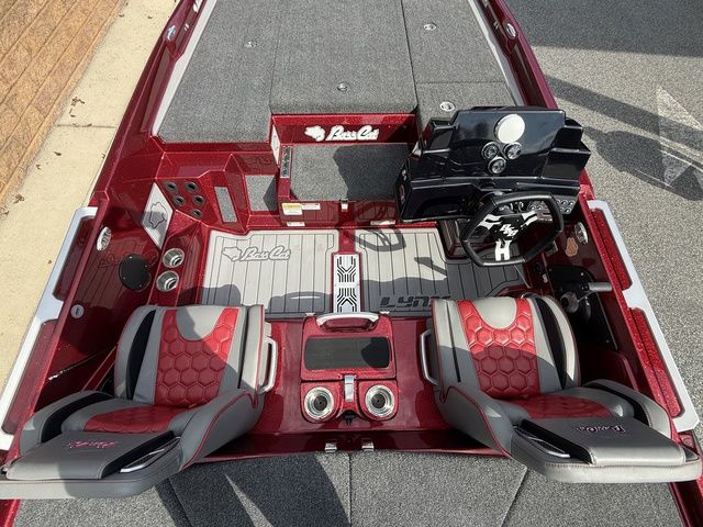 2026 Bass Cat Lynx STS boat interior with red and gray seating, dashboard, and storage compartments.
